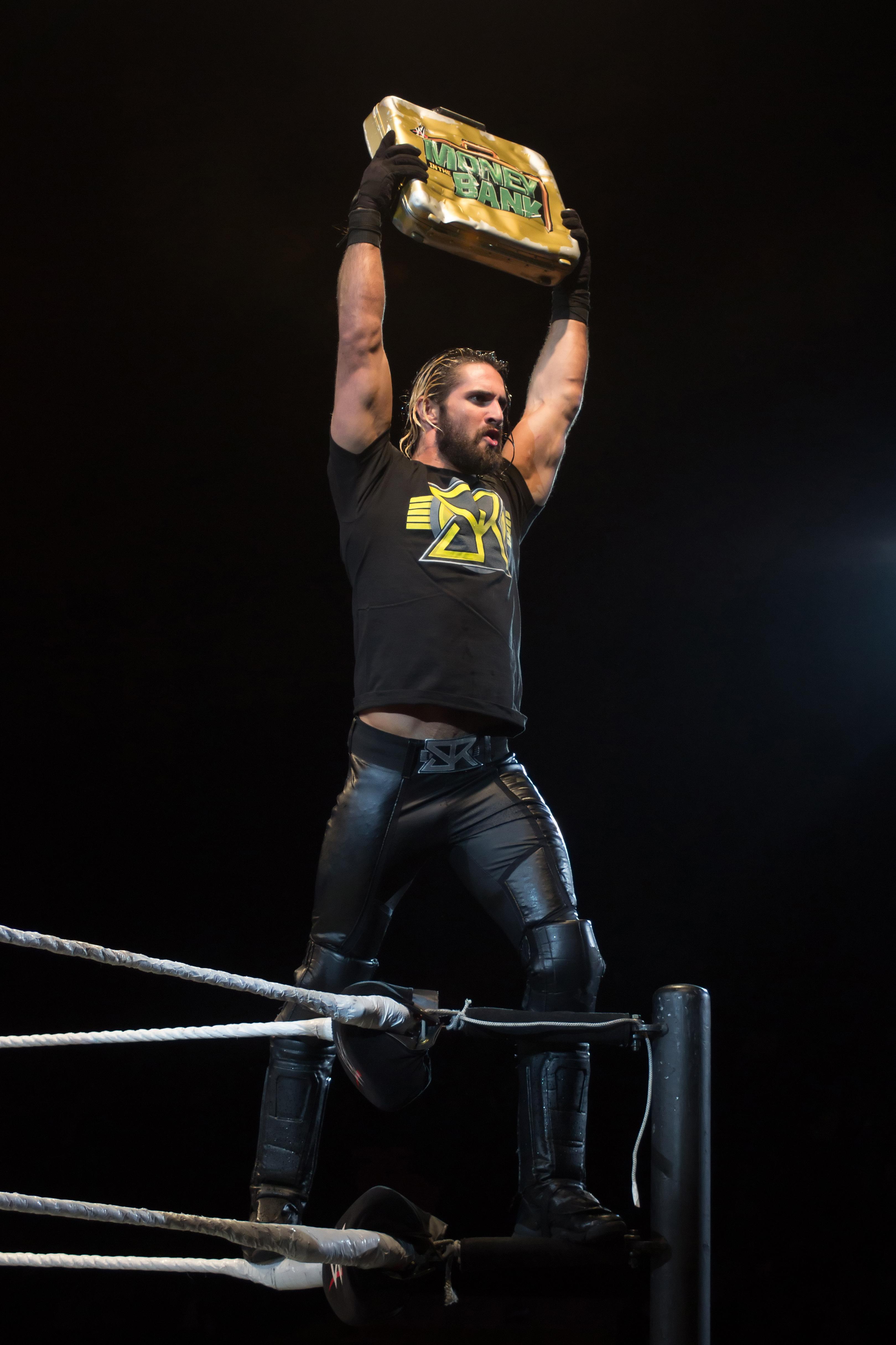 Seth Rollins holds Money in the Bank briefcase at a WWE house
