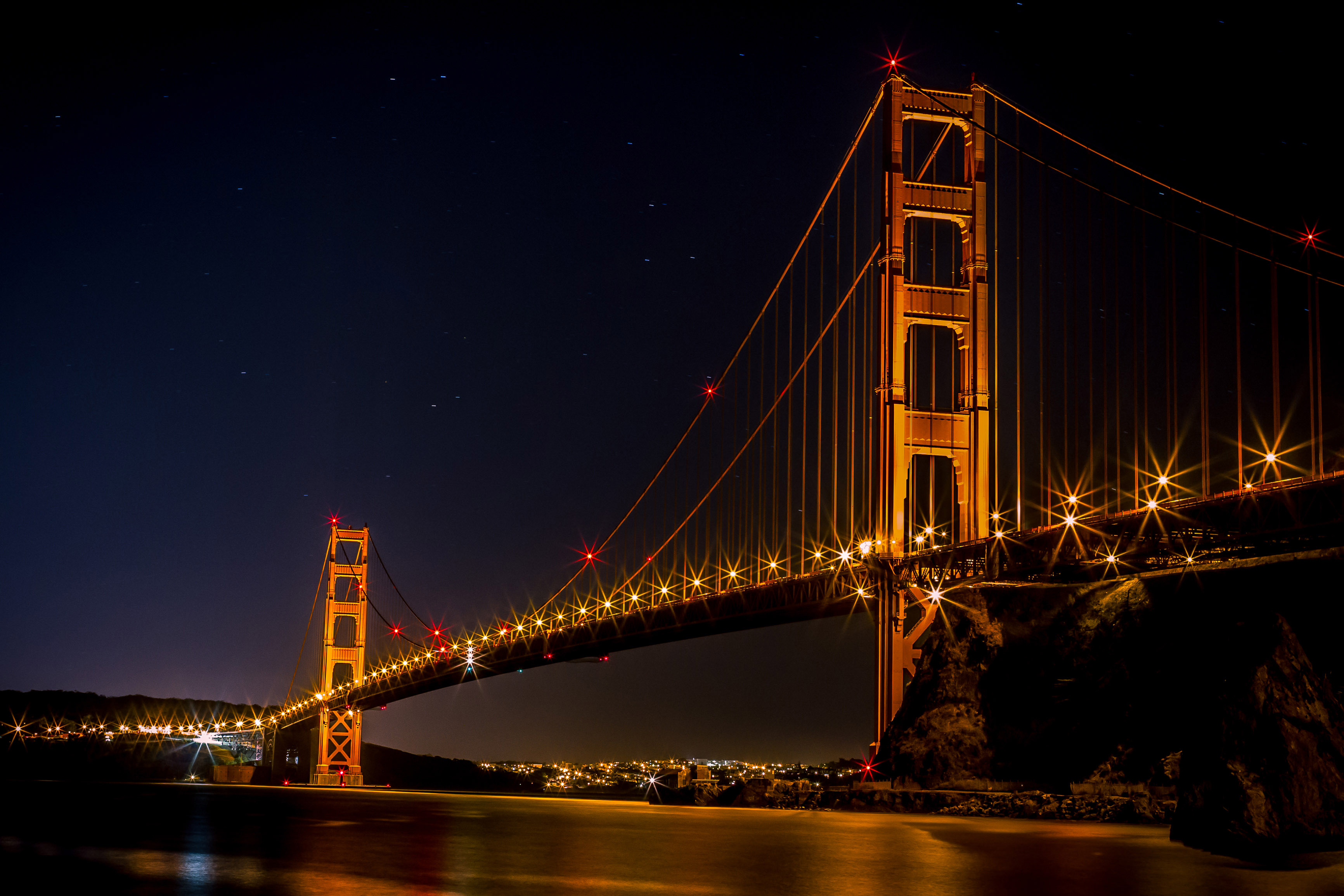 Golden Gate Bridge over the bay at night illuminated in Gold in San