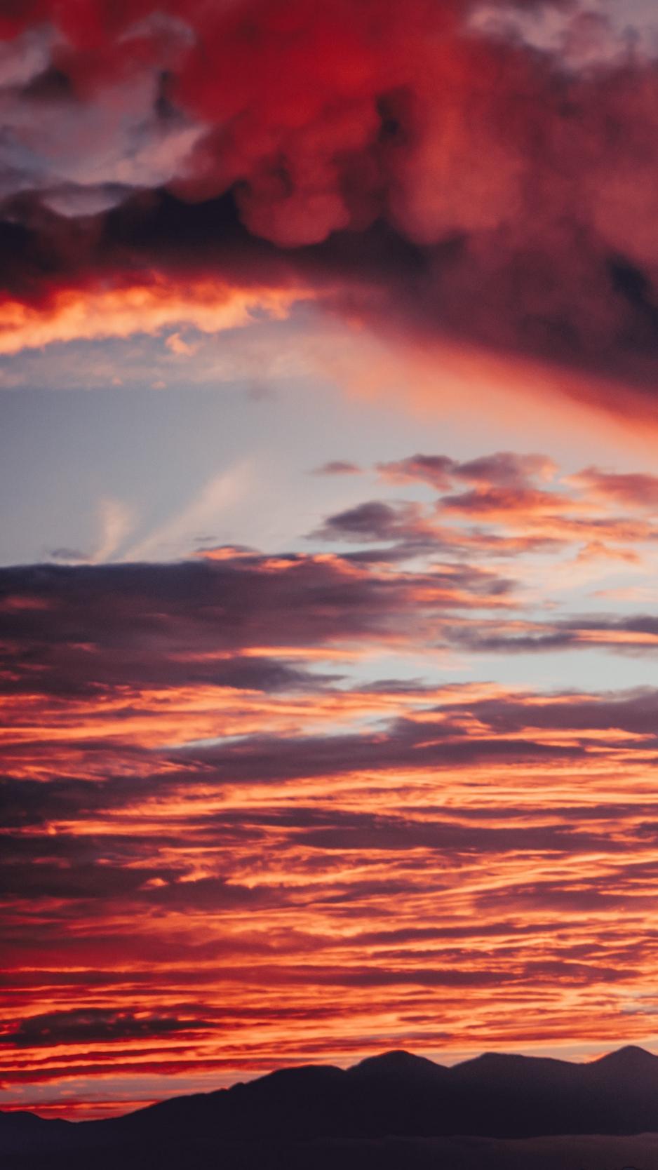 Download wallpaper 938x1668 clouds, sunset, mountains, red, fiery