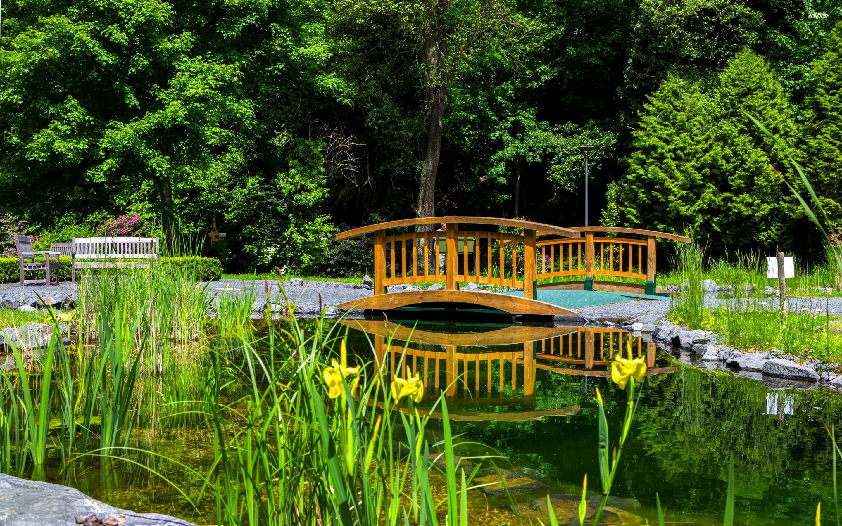 Wooden small bridge over the garden lake wallpaper