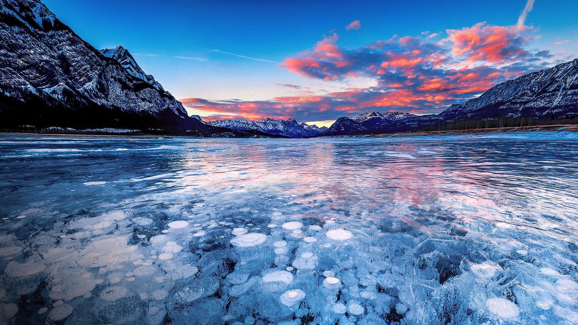 Methane bubbles under ice, sunset at Abraham Lake, Alberta, Canada