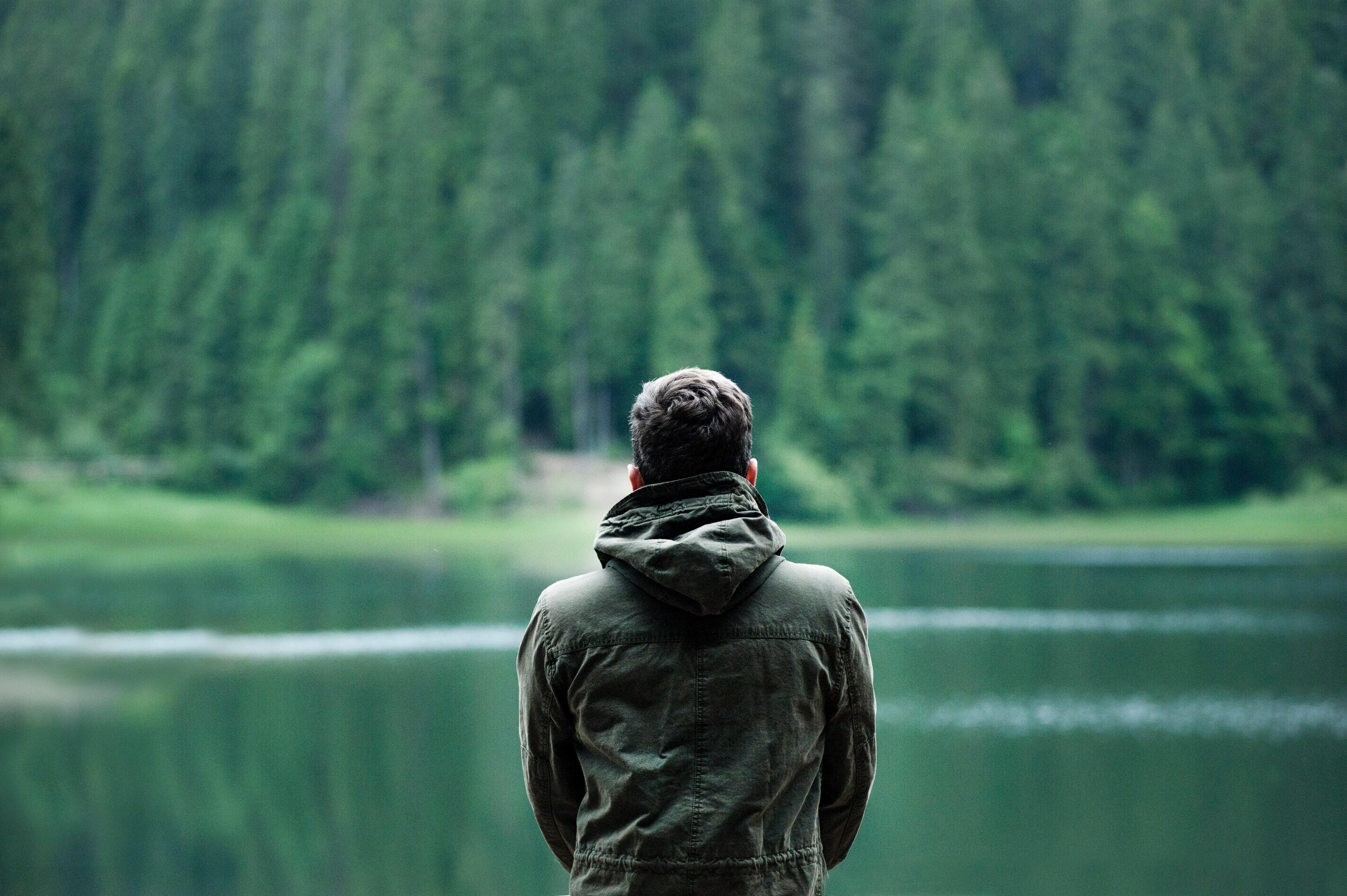 Photo of Man Wearing Hooded Jacket in Front of Body of Water · Free