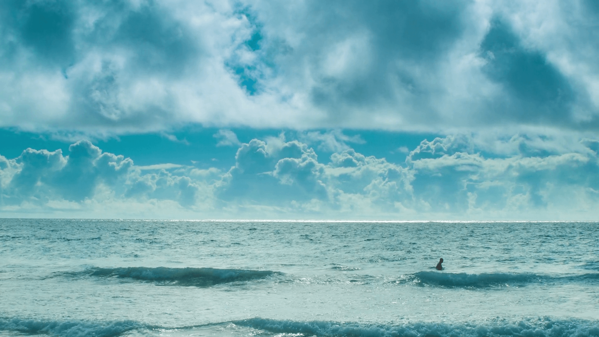 Man Swimming Alone in a Vast Ocean in the Bermuda Triangle in Front