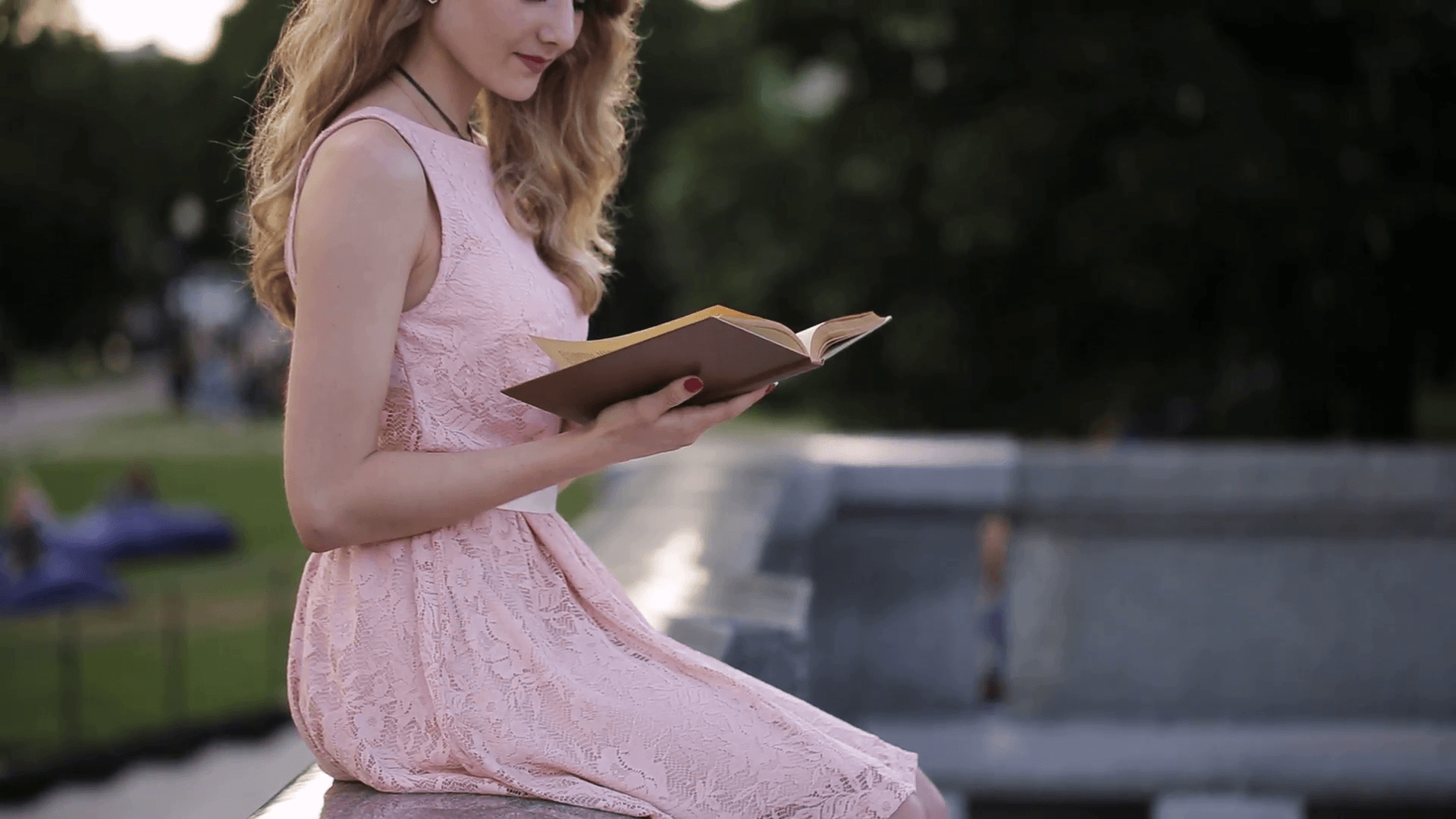 Beautiful girl reading a book in a park and dreaming about love