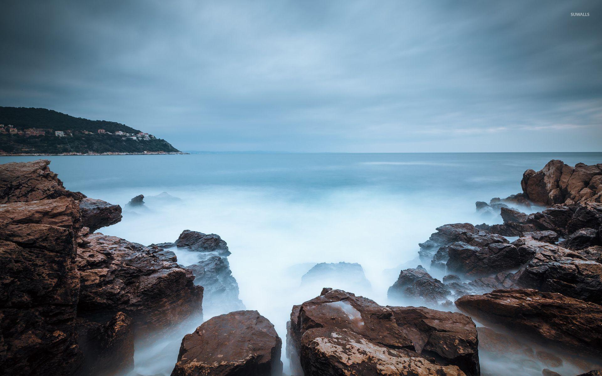 Misty water reaching to the rocky shore wallpaper wallpaper