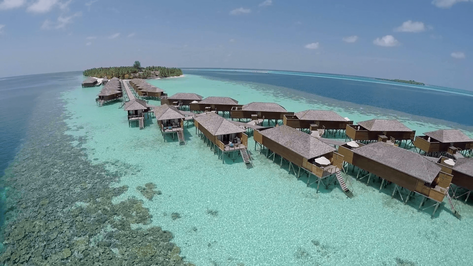 AERIAL: Luxurious Over Water Villas On Tropical Island Resort