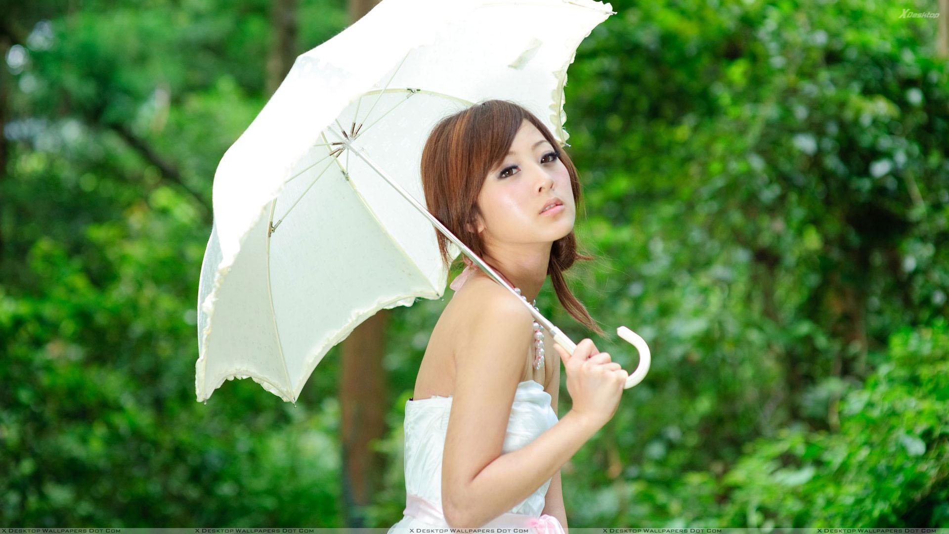 Asian Girl Thinking With White Umbrella in Green Garden Wallpaper