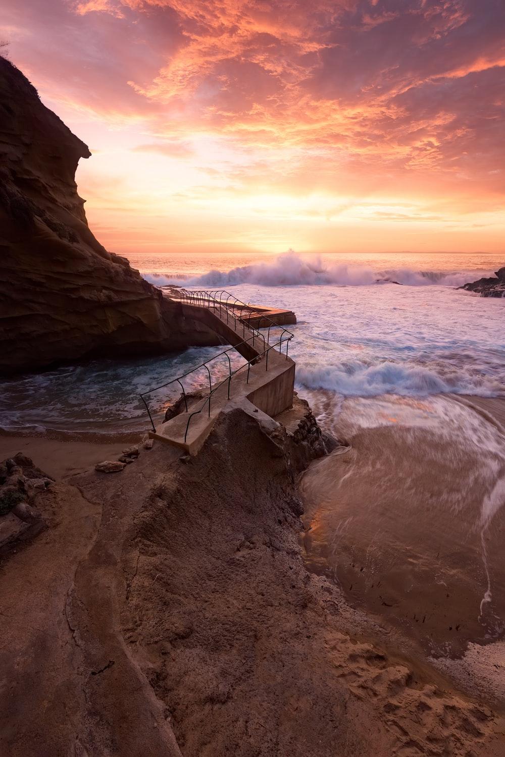 waves crashing on rocky coast during sunset photo