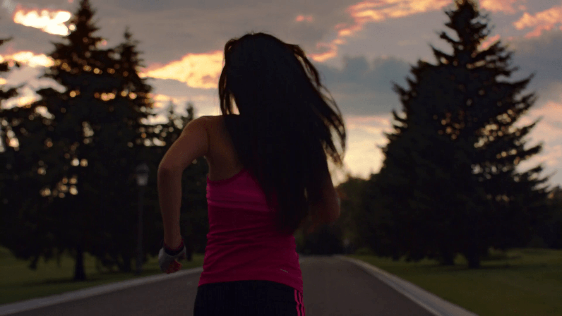Woman running at sunrise sky background. Running woman silhouette in slow motion. Woman running in park at morning. Morning fitness training. Fitness woman running away on road