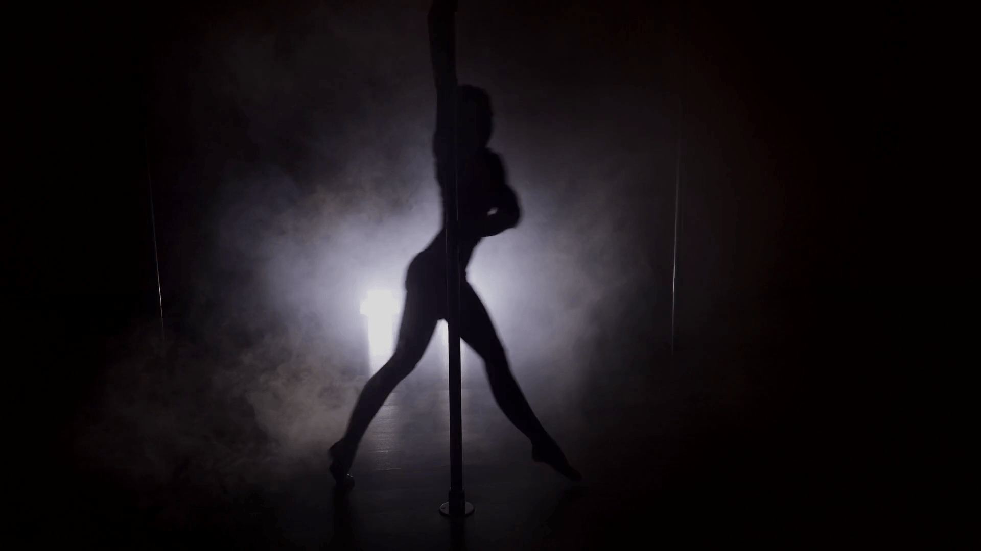Silhouette of a woman dancing with the pole with smoke Stock Video Footage