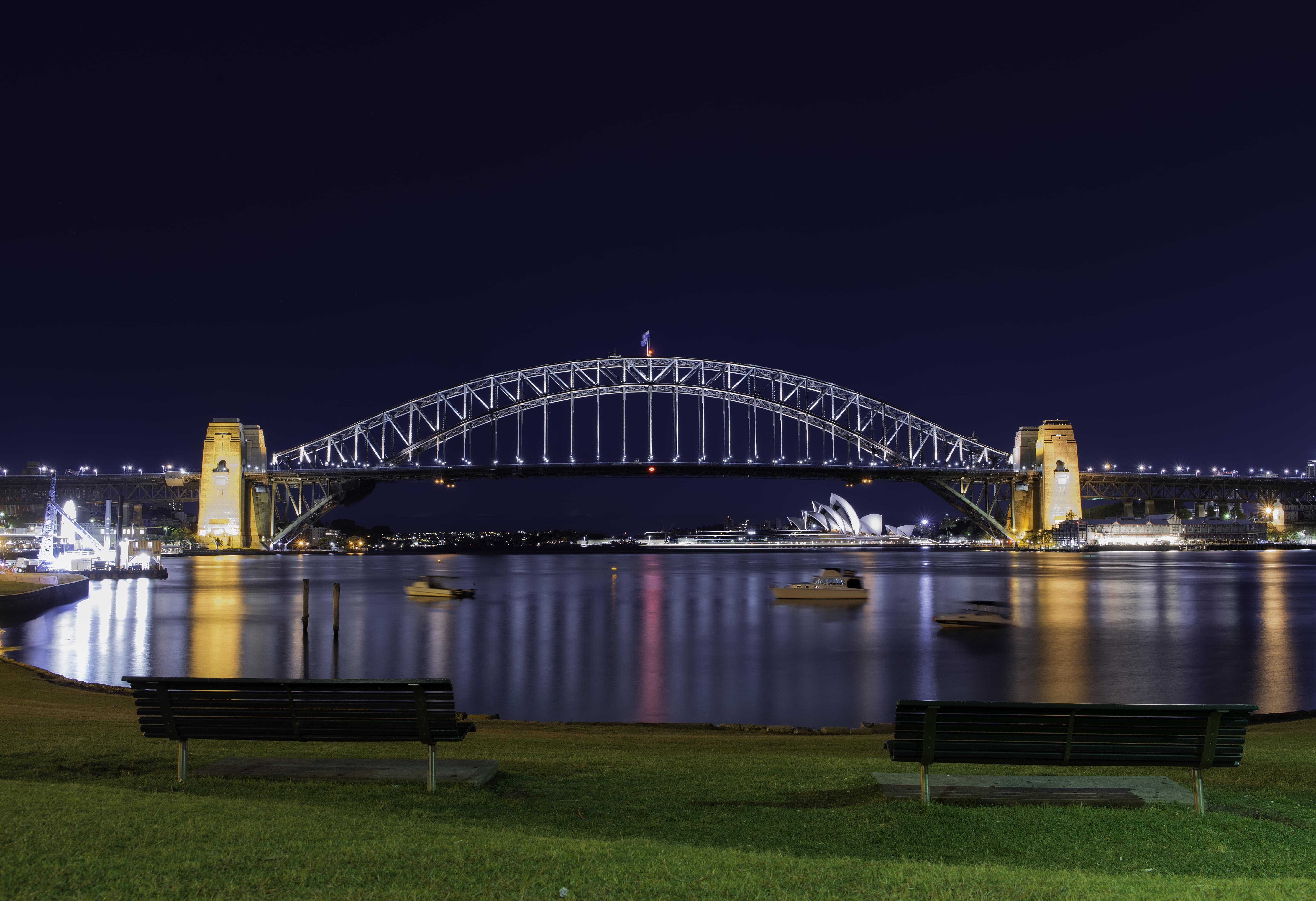 Night view of bridge with boats crossing under during