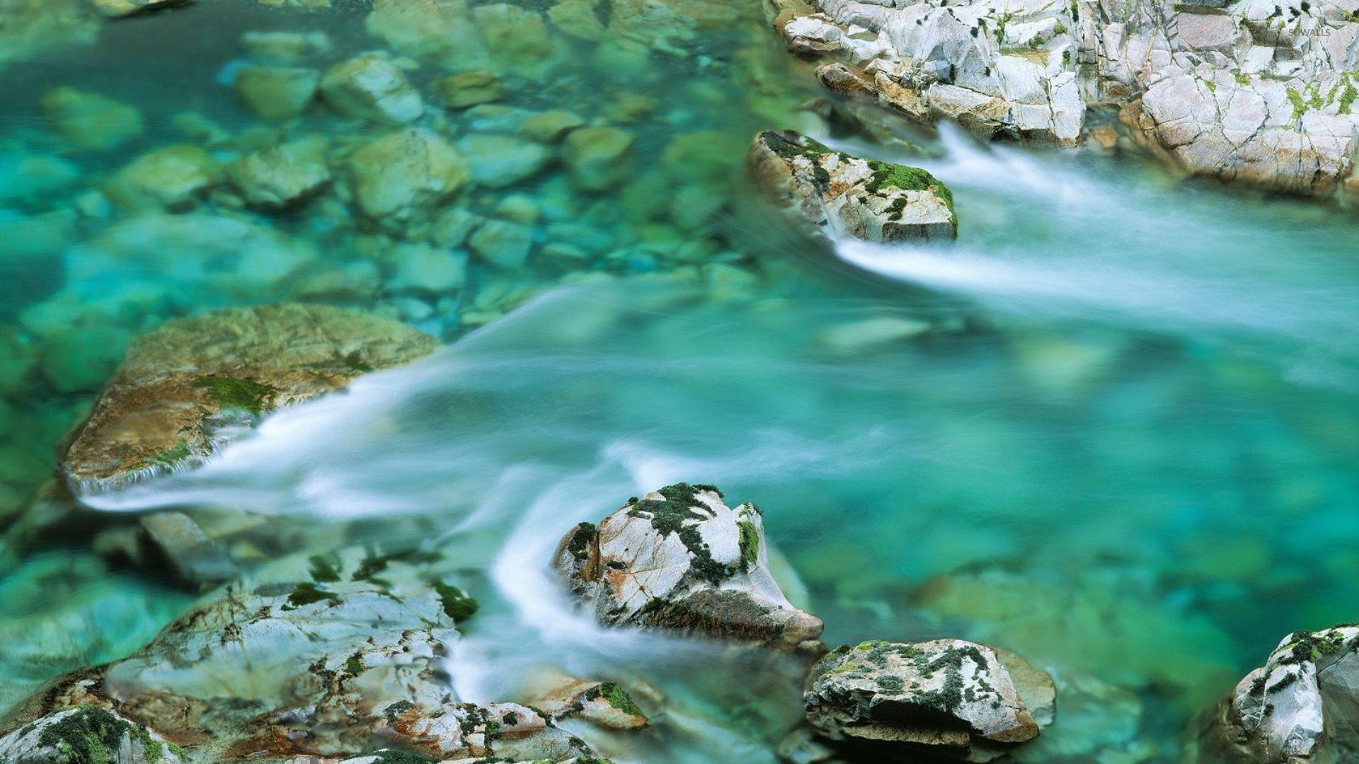 Clear water river washing the mossy rocks wallpaper