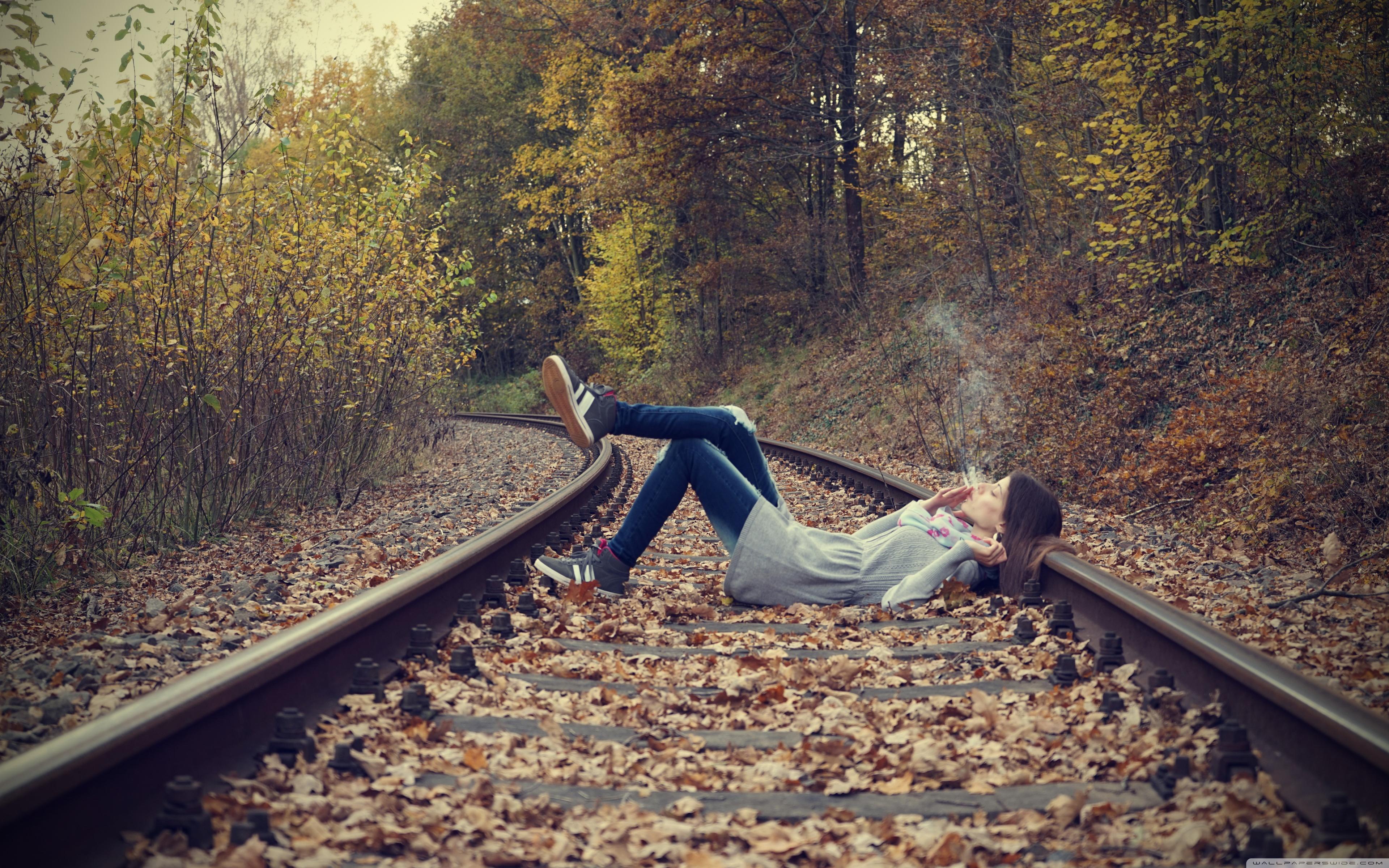 Девушка лежит на железной дороге
