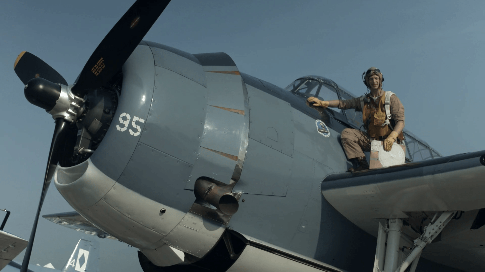 Pilot Re Enactor In Authentic Flight Gear Poses By The Cockpit Of A US Navy Grumman Avenger From World War II. Wide View, Mute. Recorded In 4K, Ultra