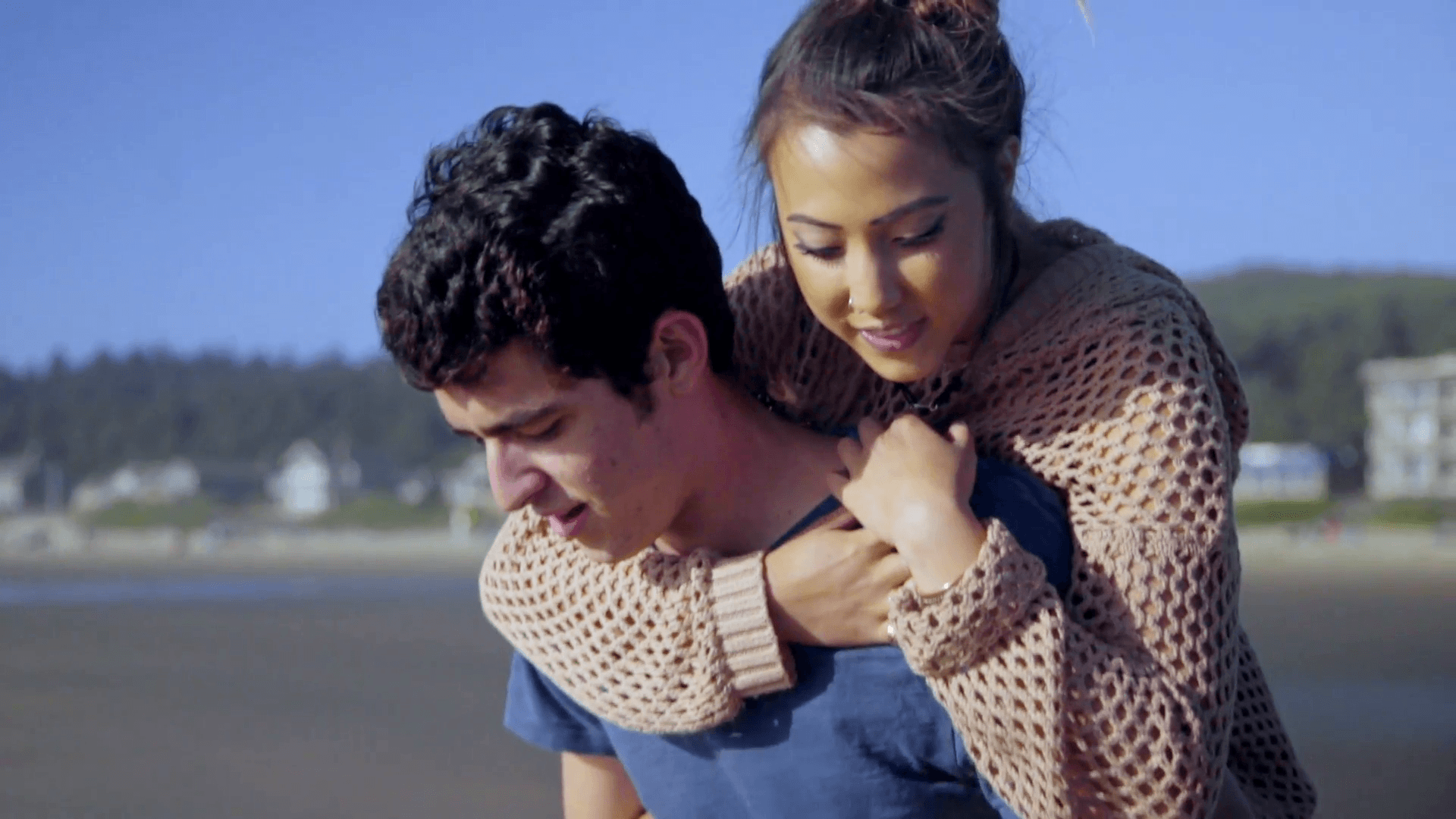Teenage couple on the beach give piggyback rides Stock Video Footage