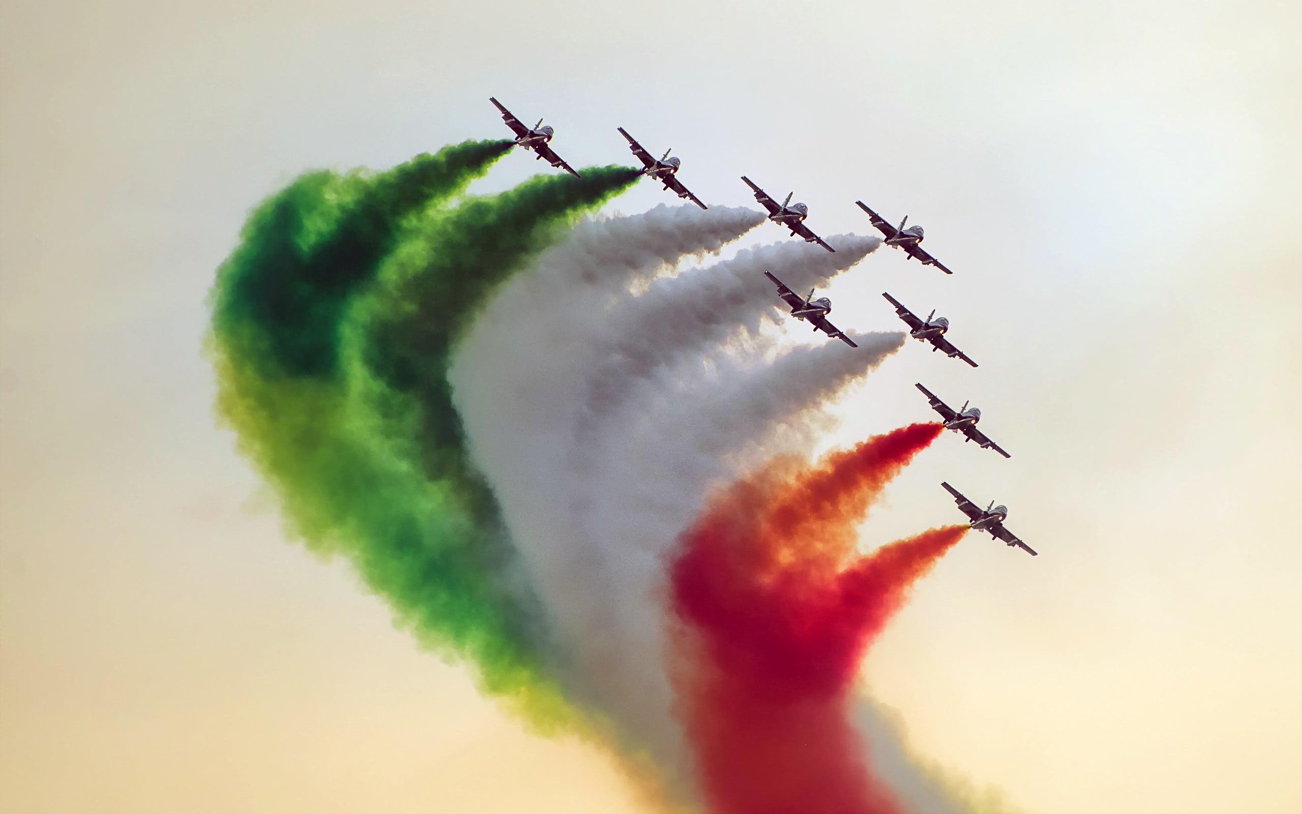 Photography of jet doing air show spraying green, white