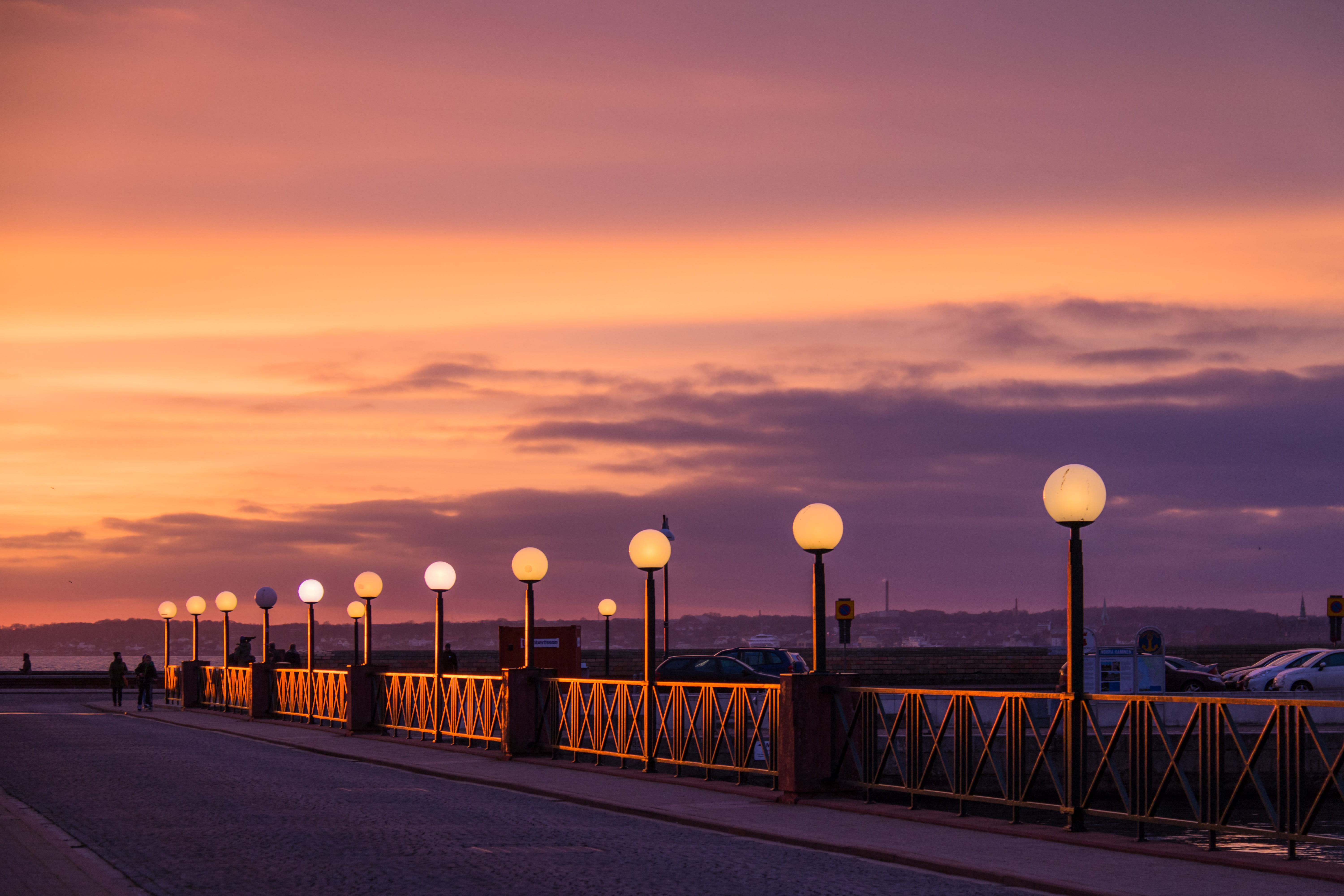 View of lighted lampposts and orange twilight sky HD