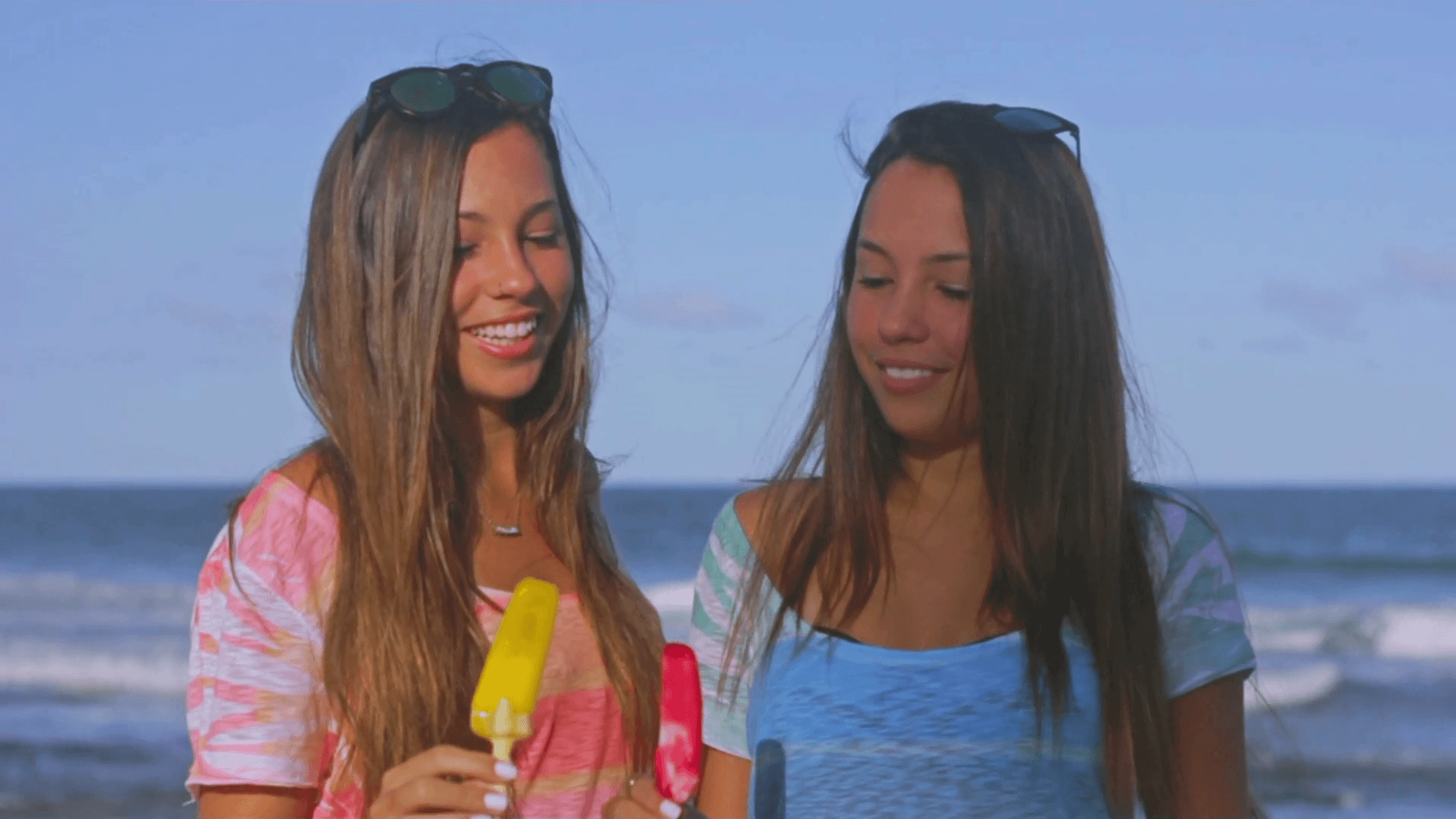 Twin Sisters Toasting Melting Popsicles In A Hot Summer Day Beach in Slow Motion Stock Video Footage
