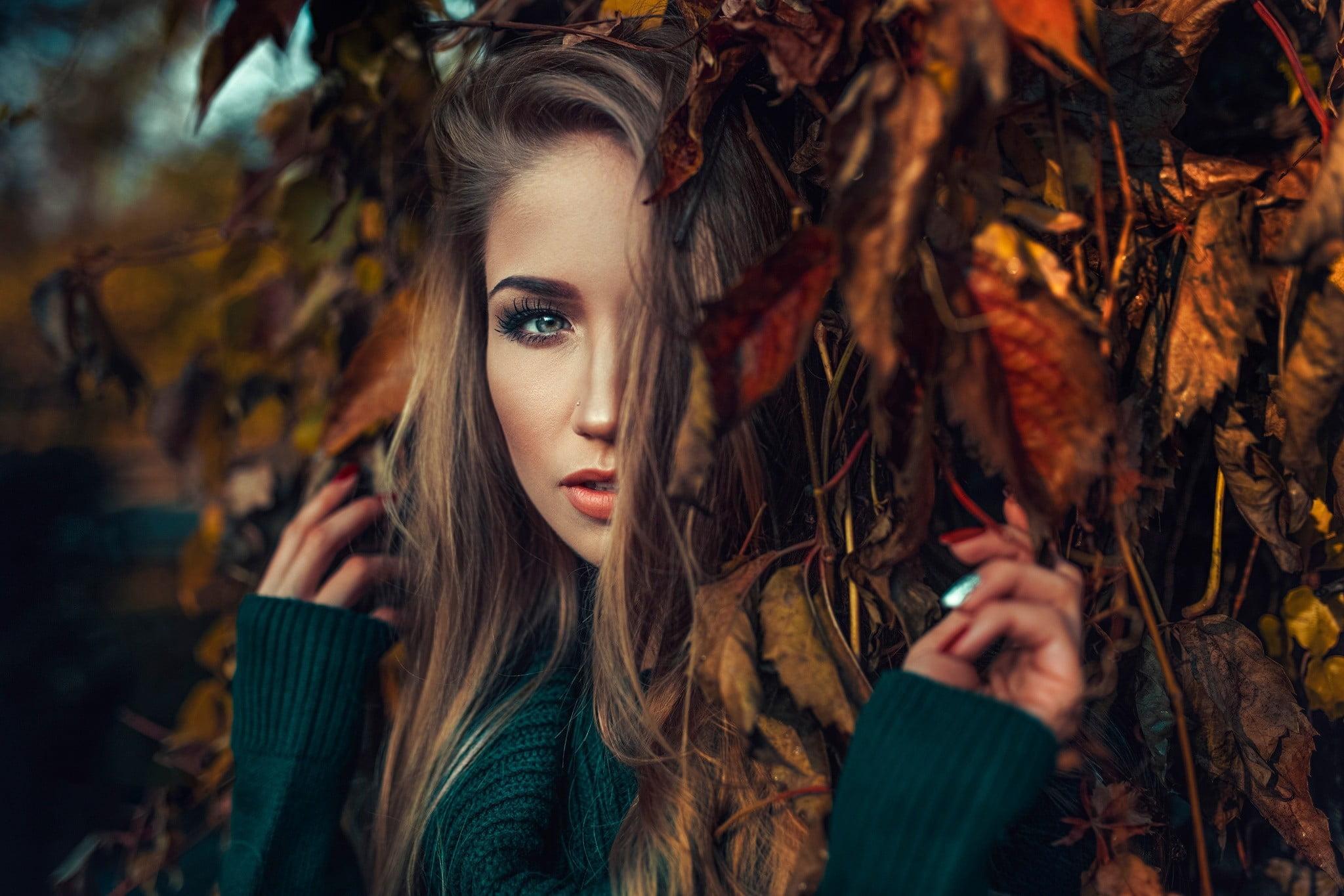 Woman wearing green sweater hiding on brown leaf tree HD