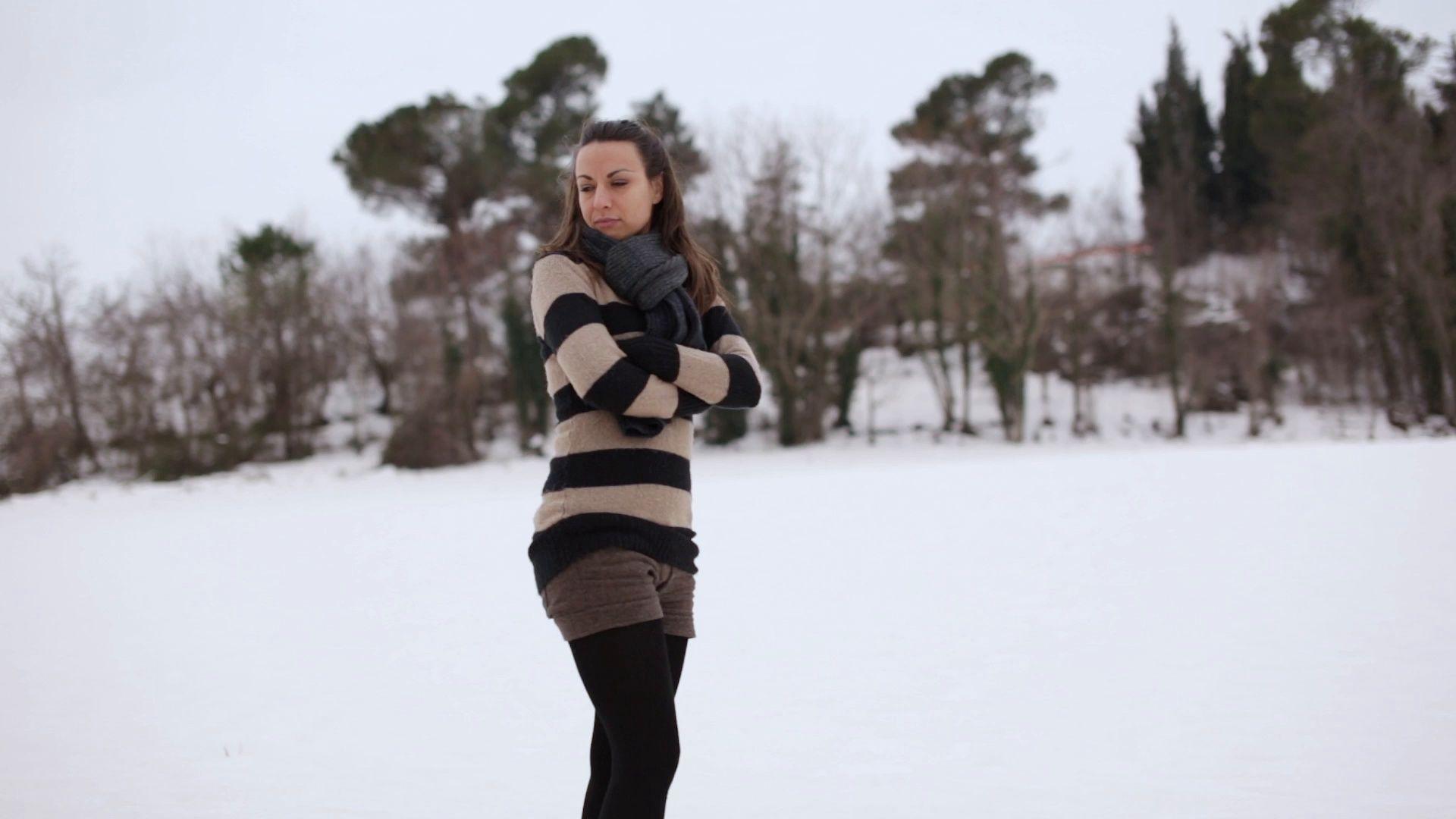 Young woman looking around in a snowy and cold environment