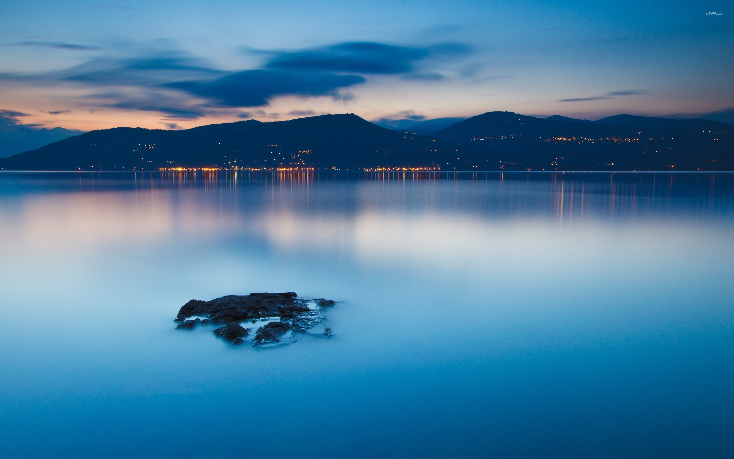 Calm lake at sunset by the city lights wallpaper
