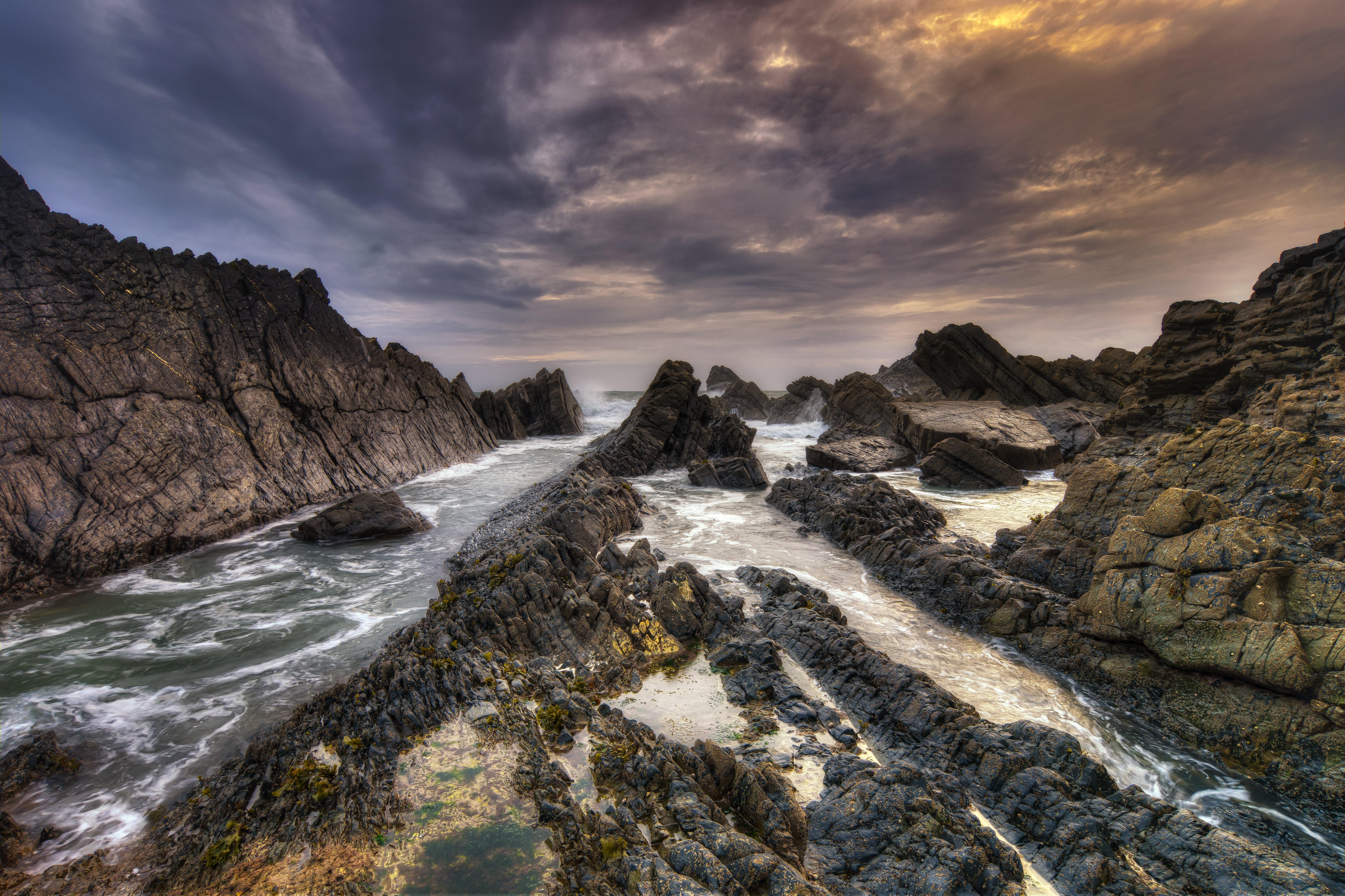 Brown and black stone formation on body of water, hartland