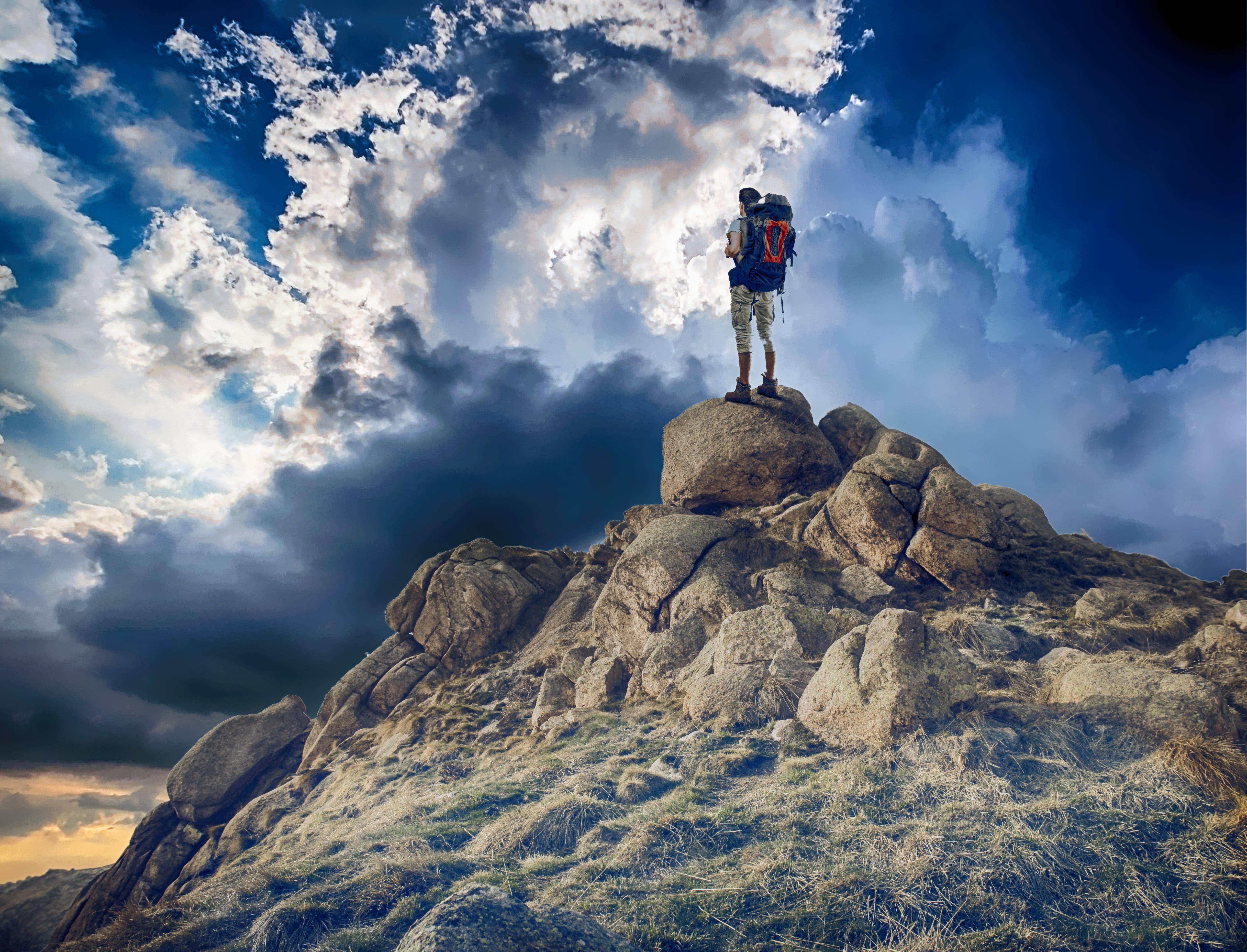 Man standing on rocks in mountain during daytime HD
