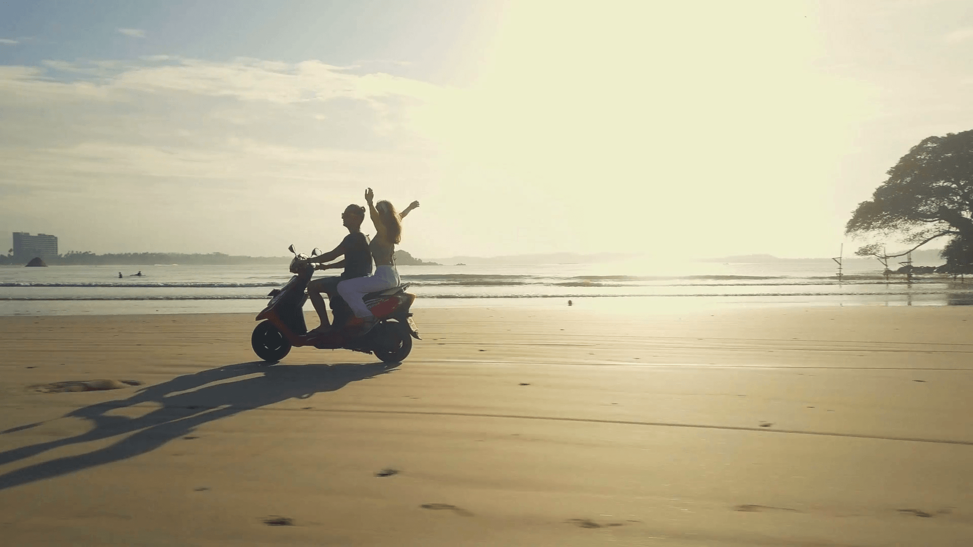 Couple riding motorbike on the beach near the water sunrise rapid slow motion Stock Video Footage