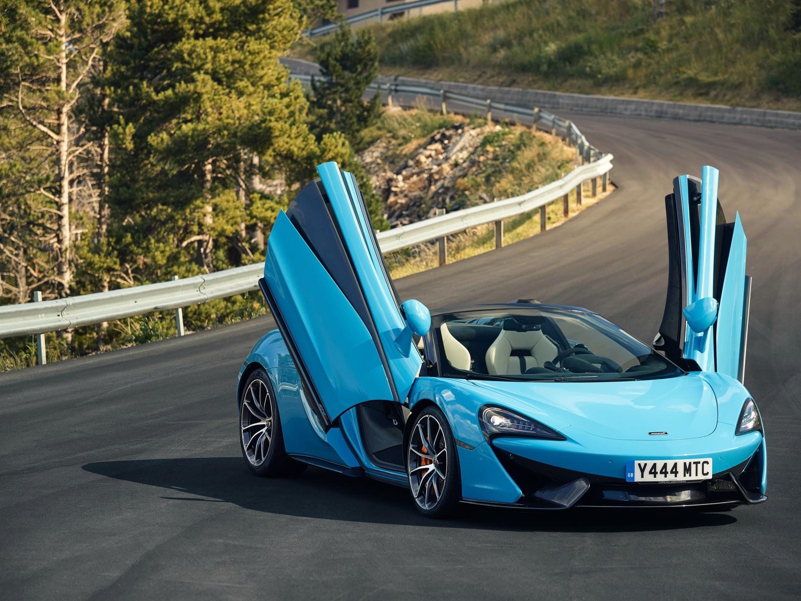 Blue sports car McLaren 570S on the road with open doors
