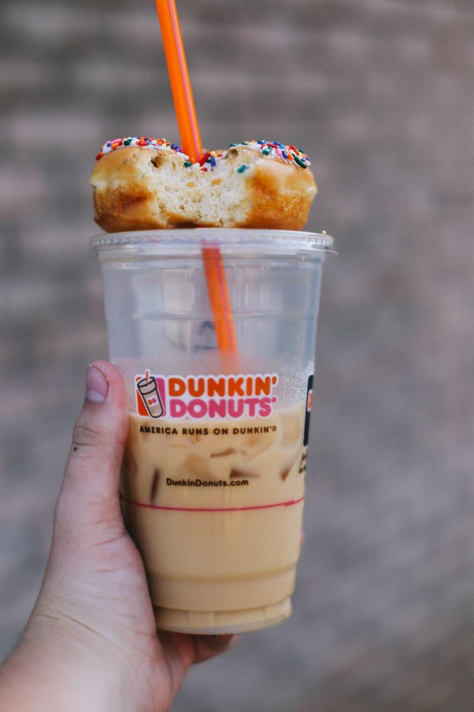 dunkin' donuts' on top of iced coffee cup and orange straw