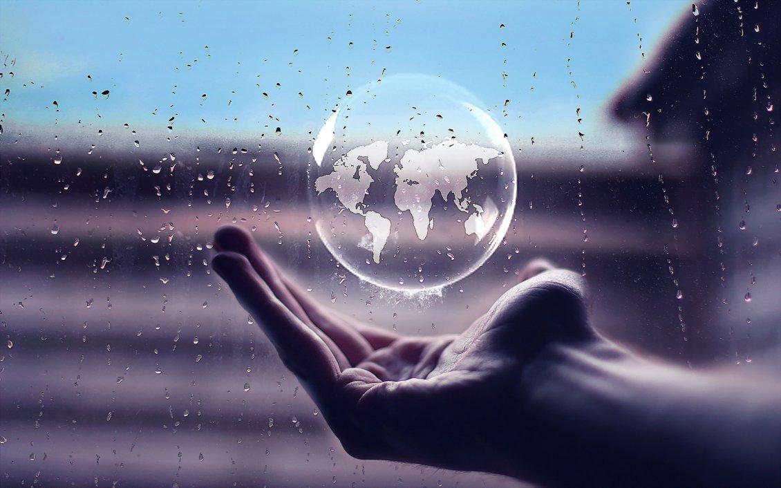 Rain bubble in hand with the earth map