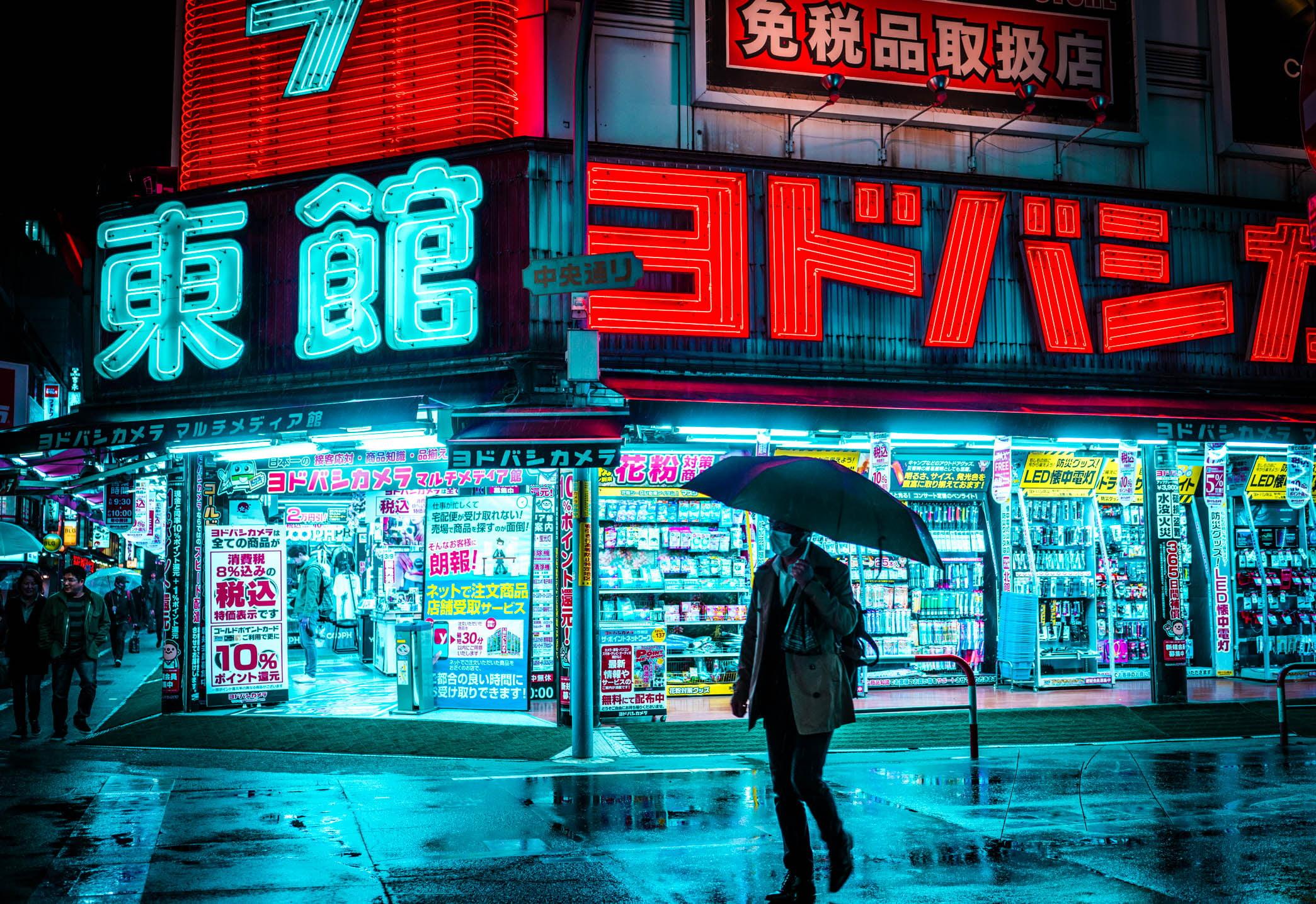 Man holding umbrella walking on the street near store during