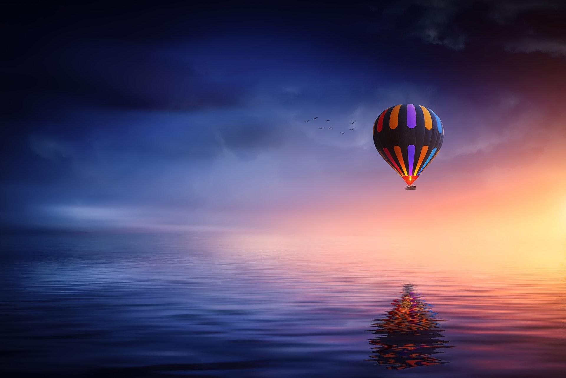 Multicolored Hot Air Balloon over Calm Sea · Free