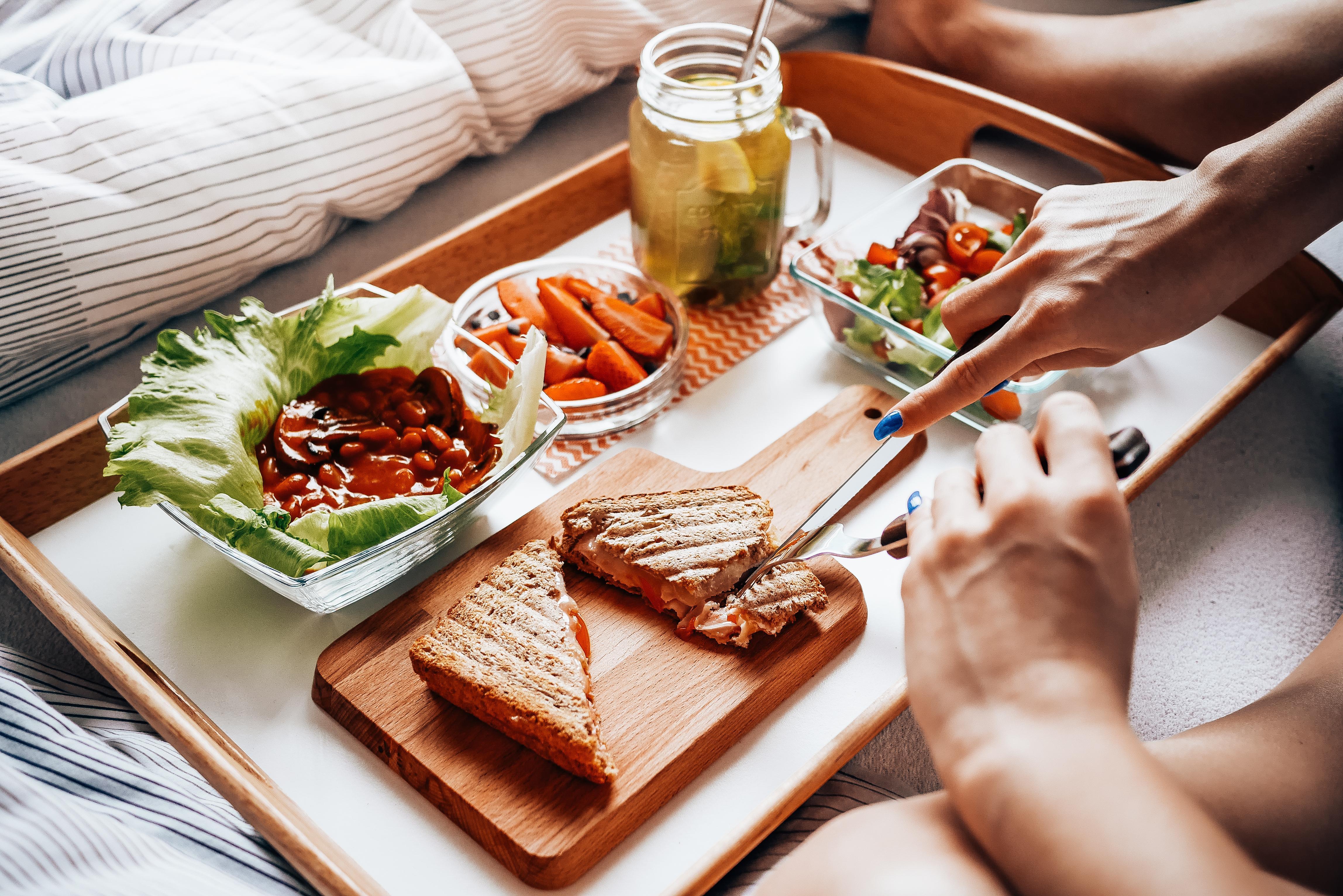 Young Woman Enjoying Morning Breakfast in Bed Free Stock