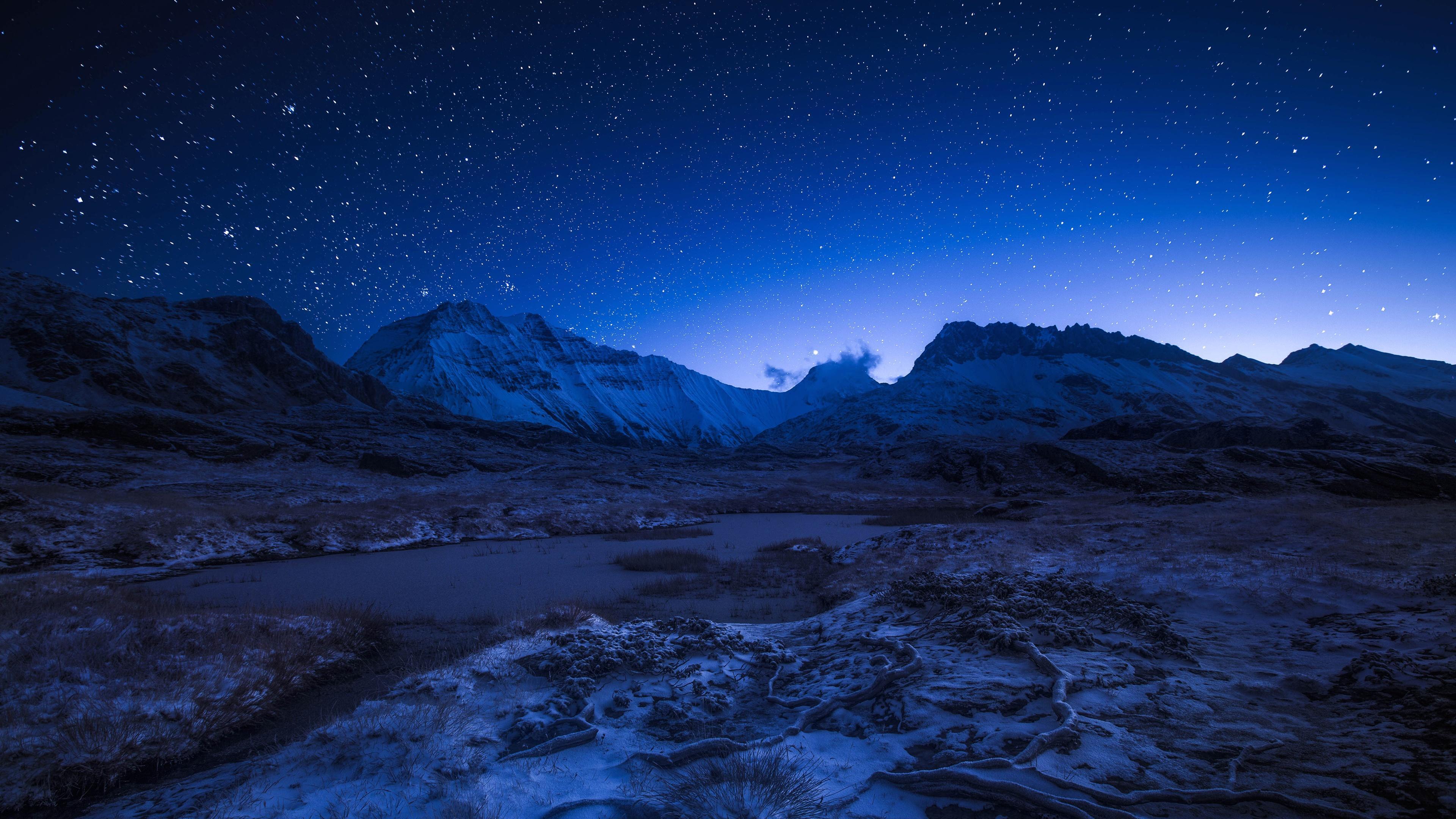 Starry night sky above the snowy mountains Wallpaper 4k