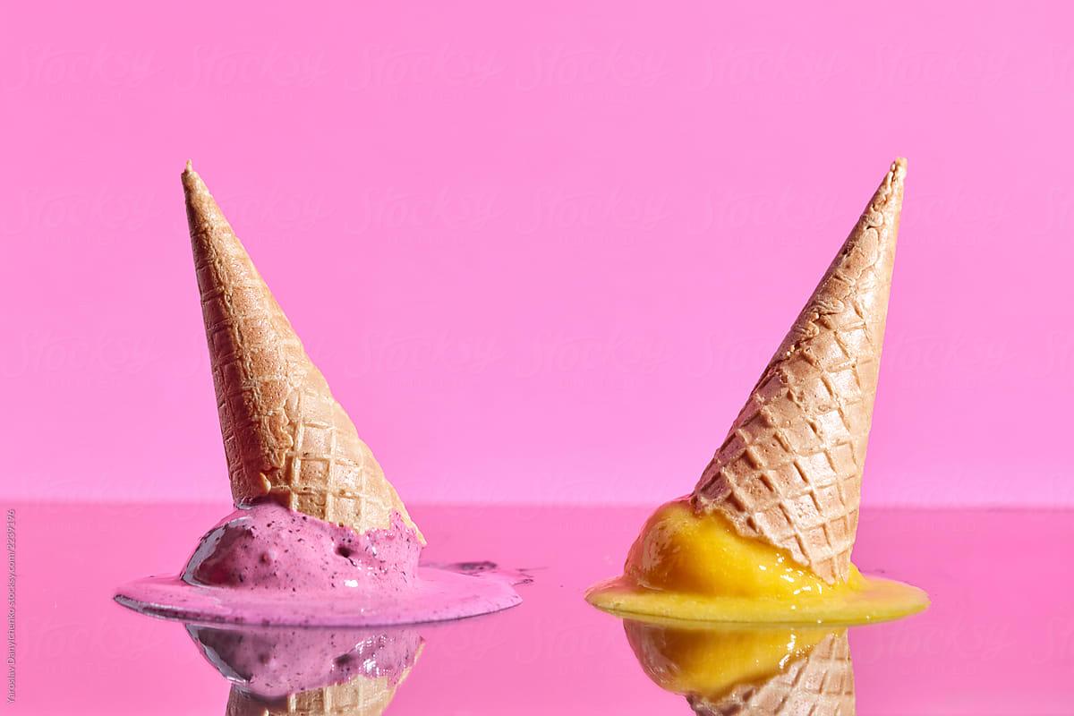 Fruit melting ice cream with wafer cones reflected on a pink