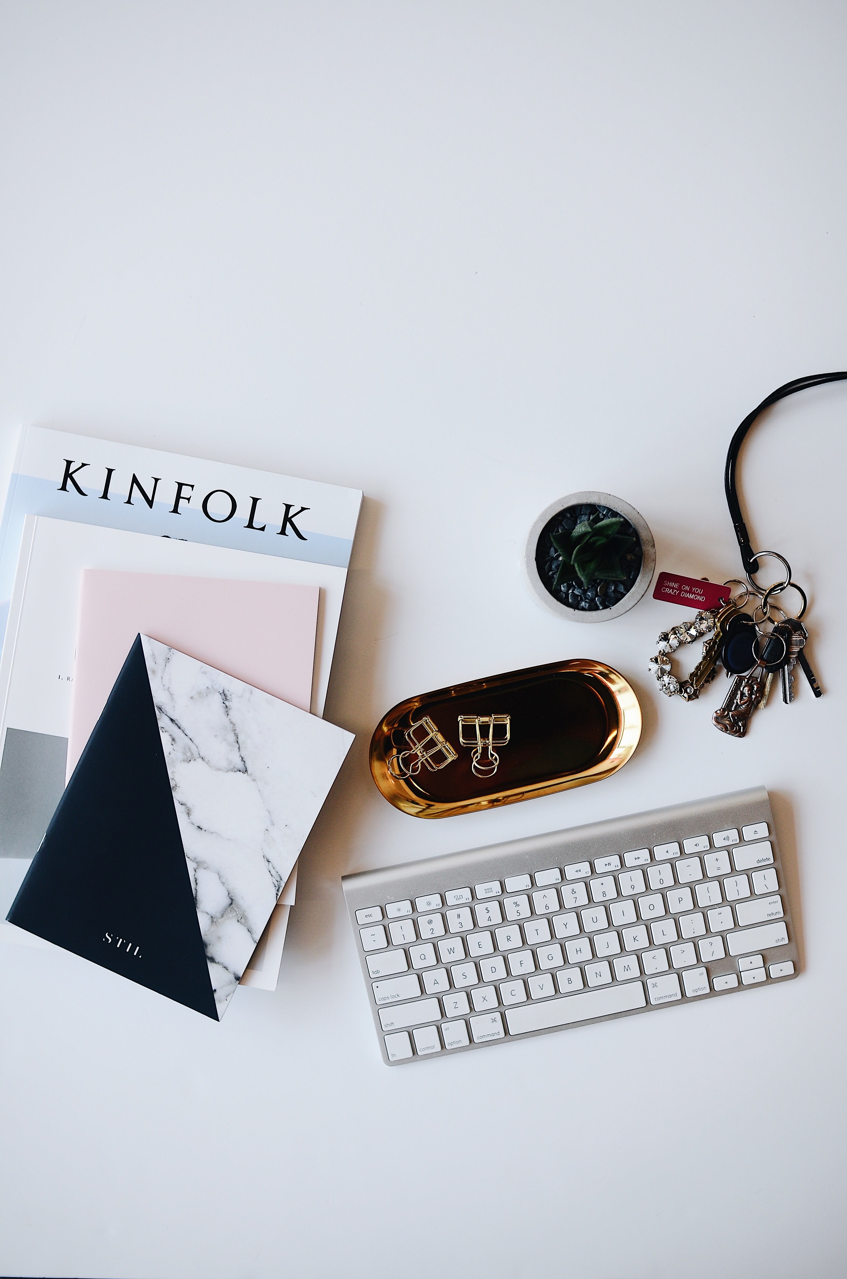 a flatlay image of a keyboard books and other items desk