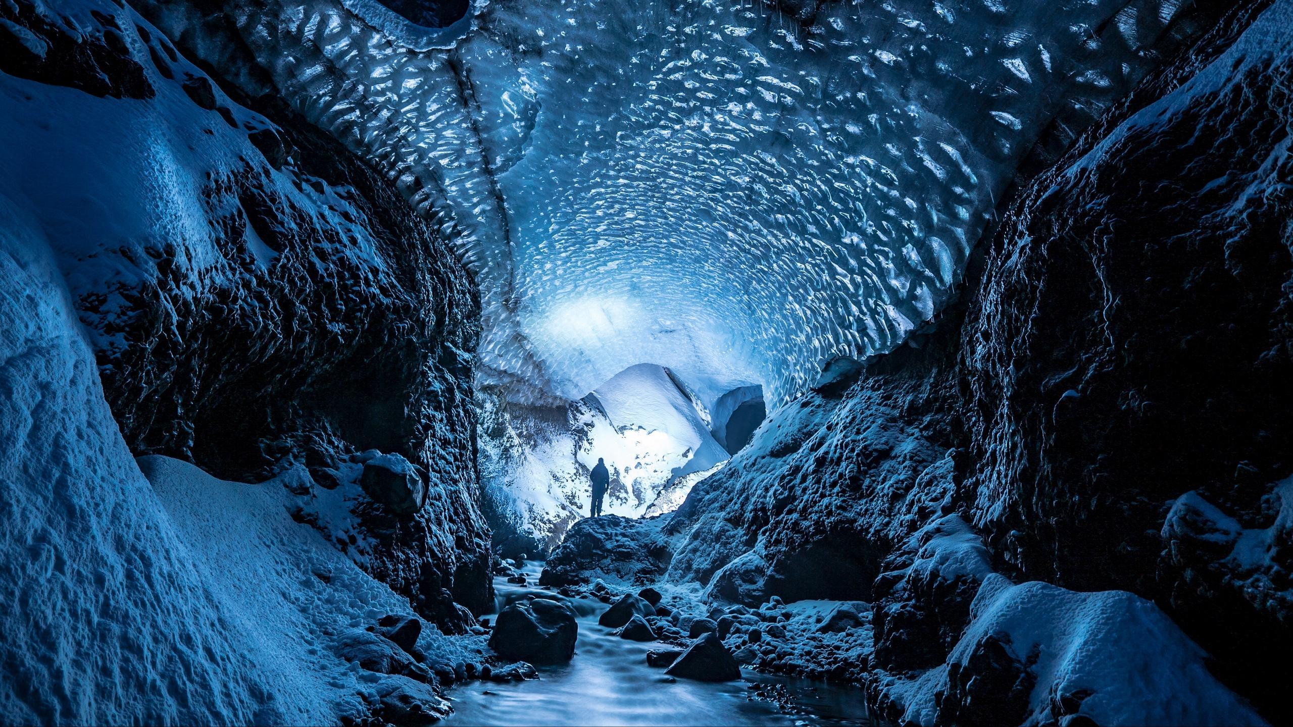 Download wallpaper 2560x1440 glacier, cave, man, ice, snow