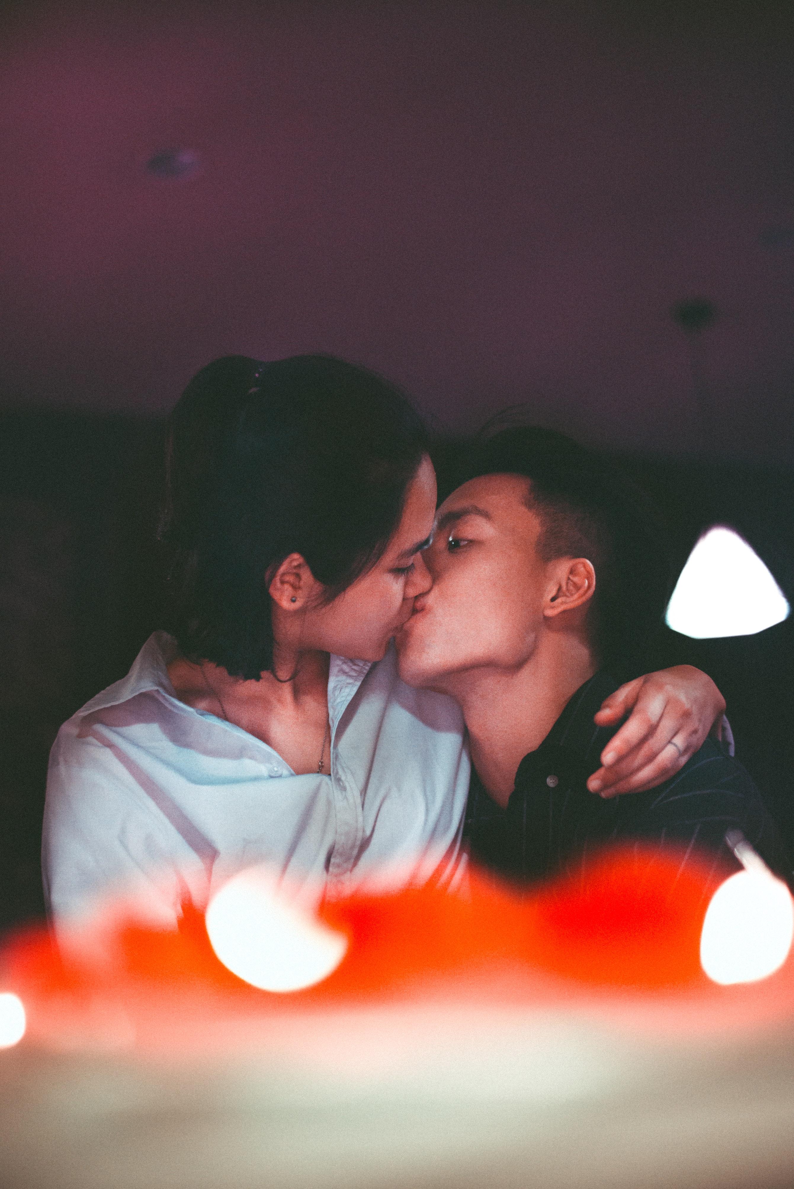 Man and Woman Kissing Near Pendant Lamp · Free