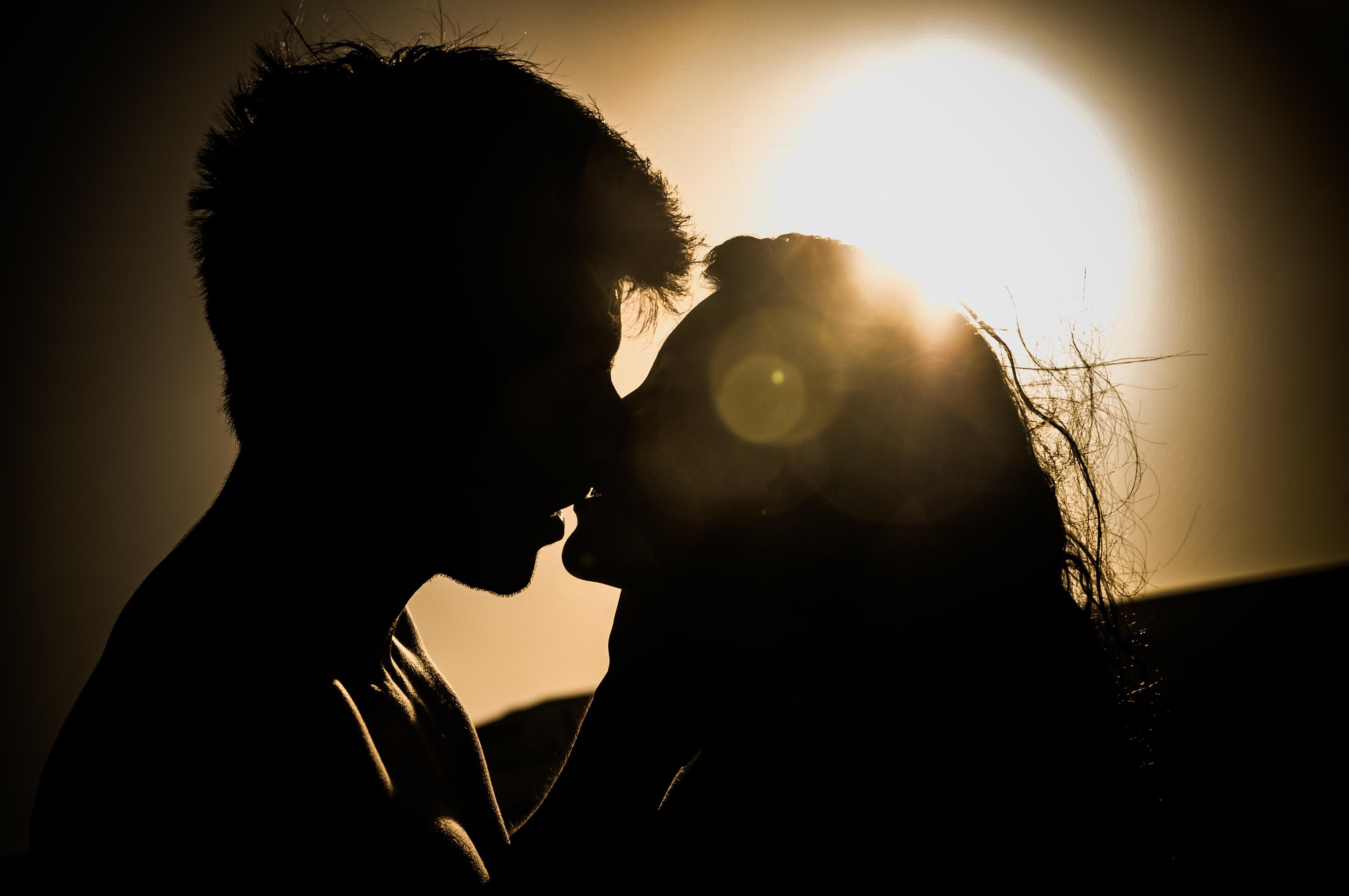 Silhouettes of Couple Kissing Against Sunset · Free