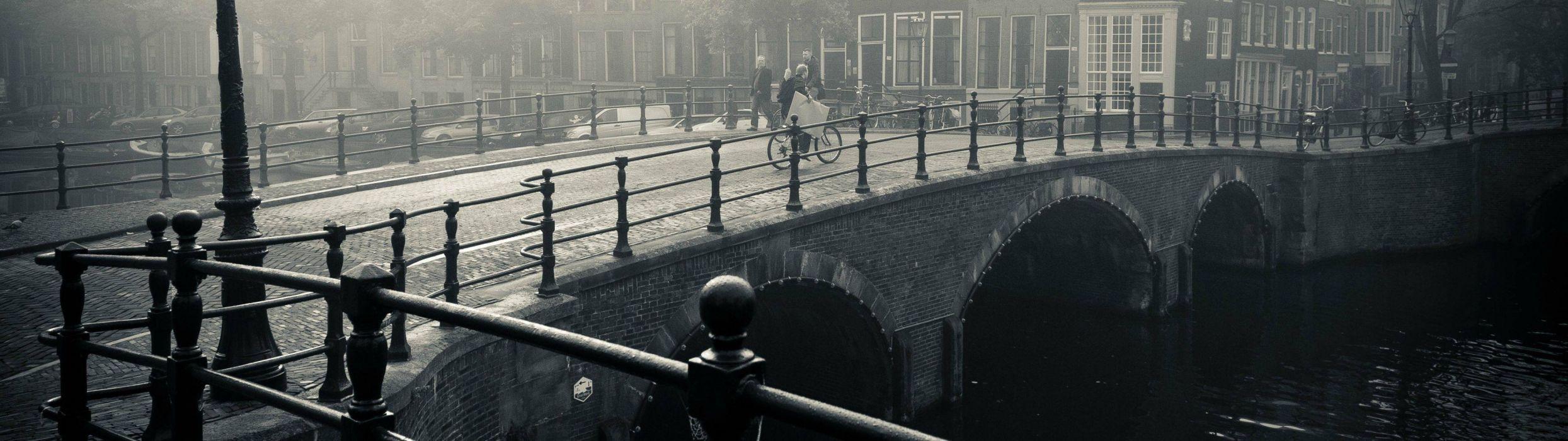 City river bridge cyclist walking downtown black and white