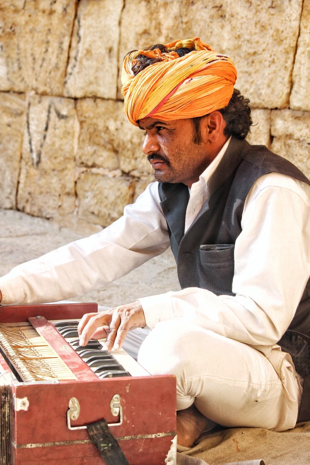 man sitting on ground playing harmonium photo
