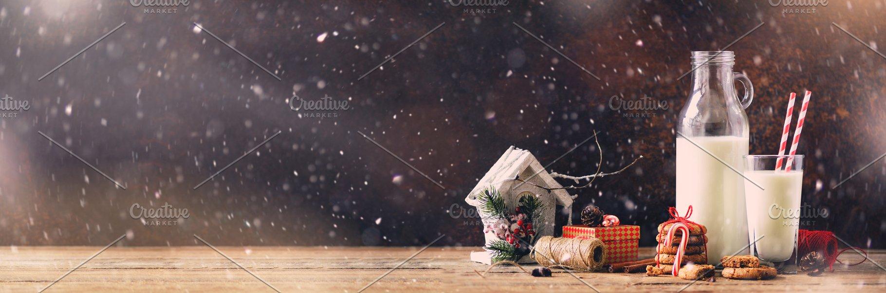 Christmas dark background with snow and bokeh, copy space. Banner. Bottle, glass with milk for Santa, cookies, red rope, anise stars, cinnamon sticks