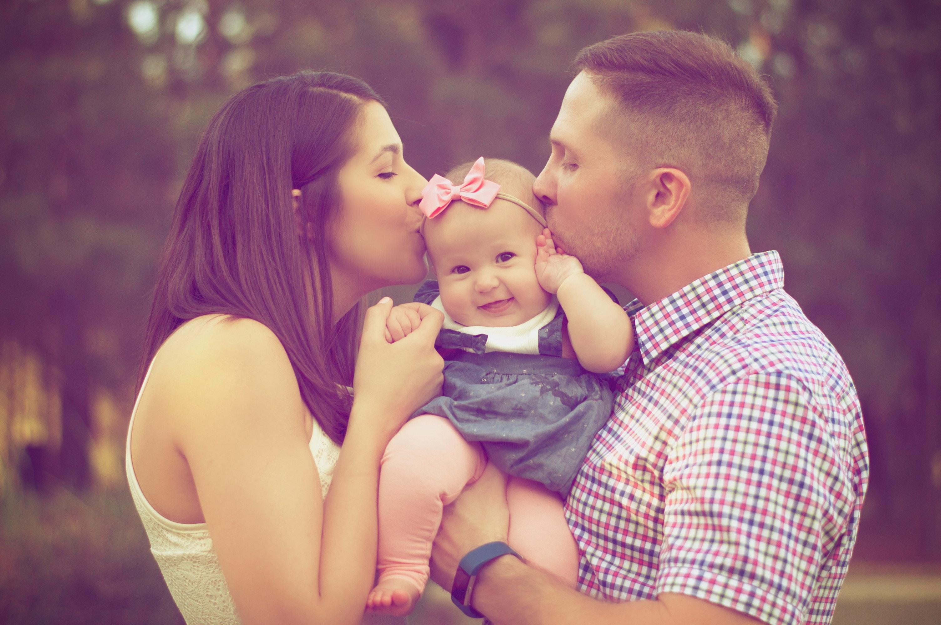Couple Kissing Baby While Carry · Free
