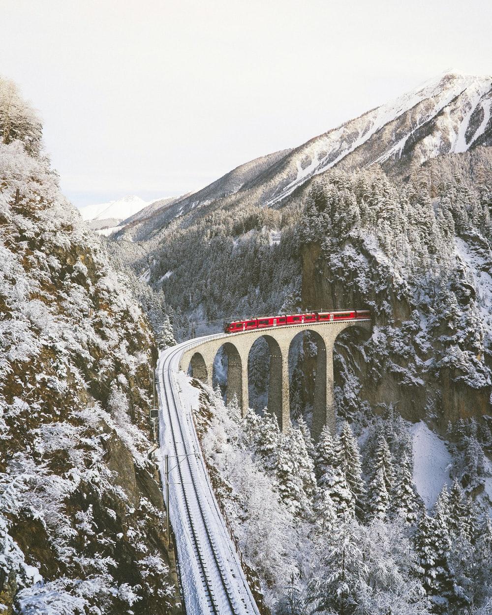approaching red train across mountains photo