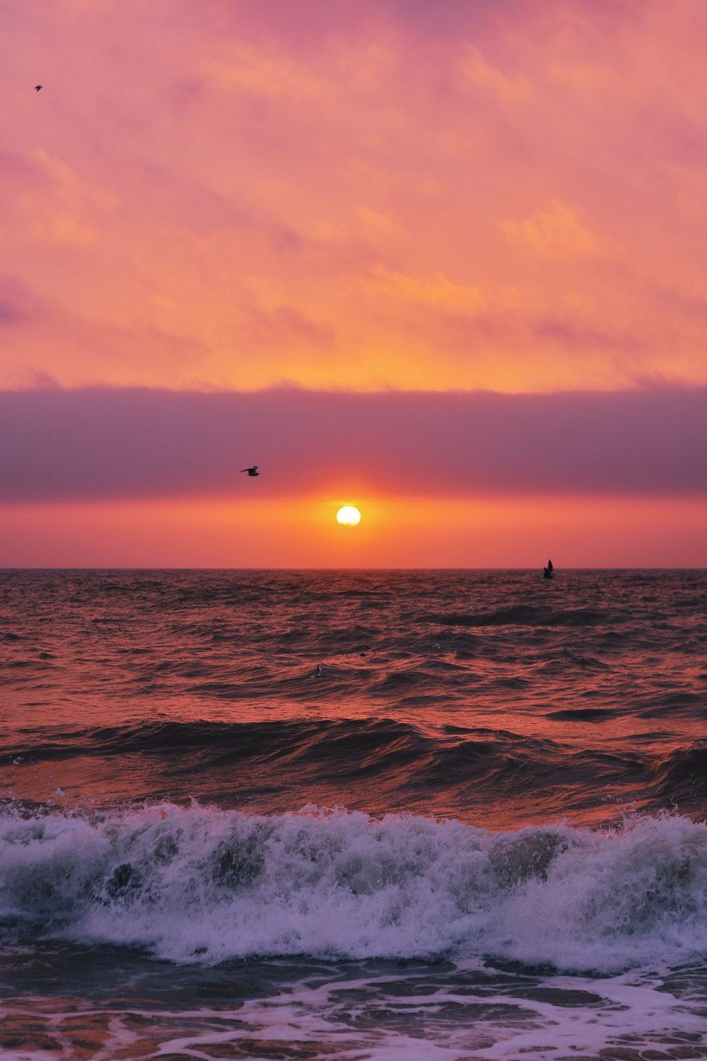 time lapse photography of ocean waves during sunset photo