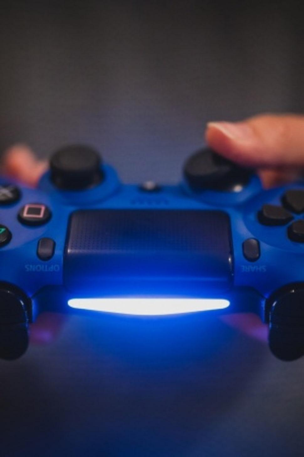 Person holding blue Sony PS4 controller HD wallpaper