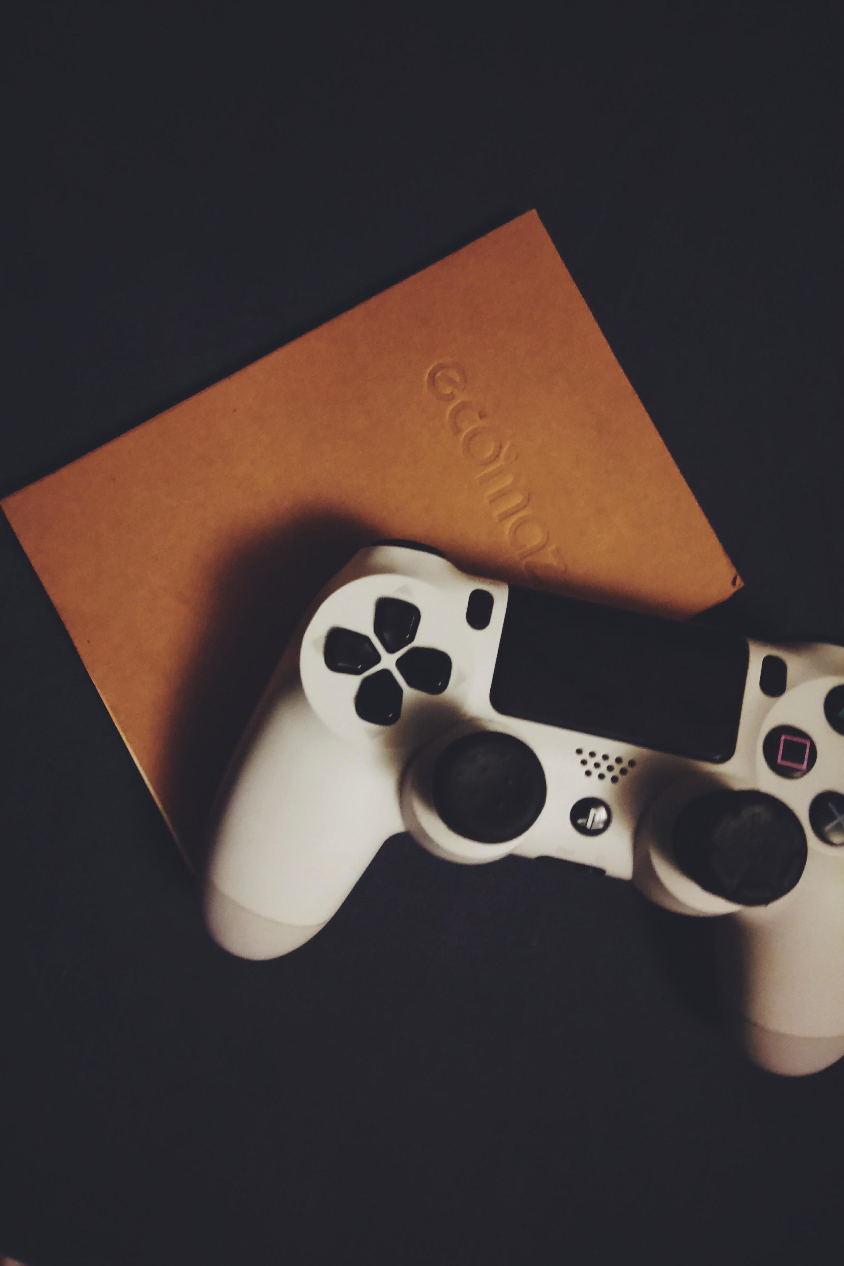 White Dualshock 4 on Brown Book · Free