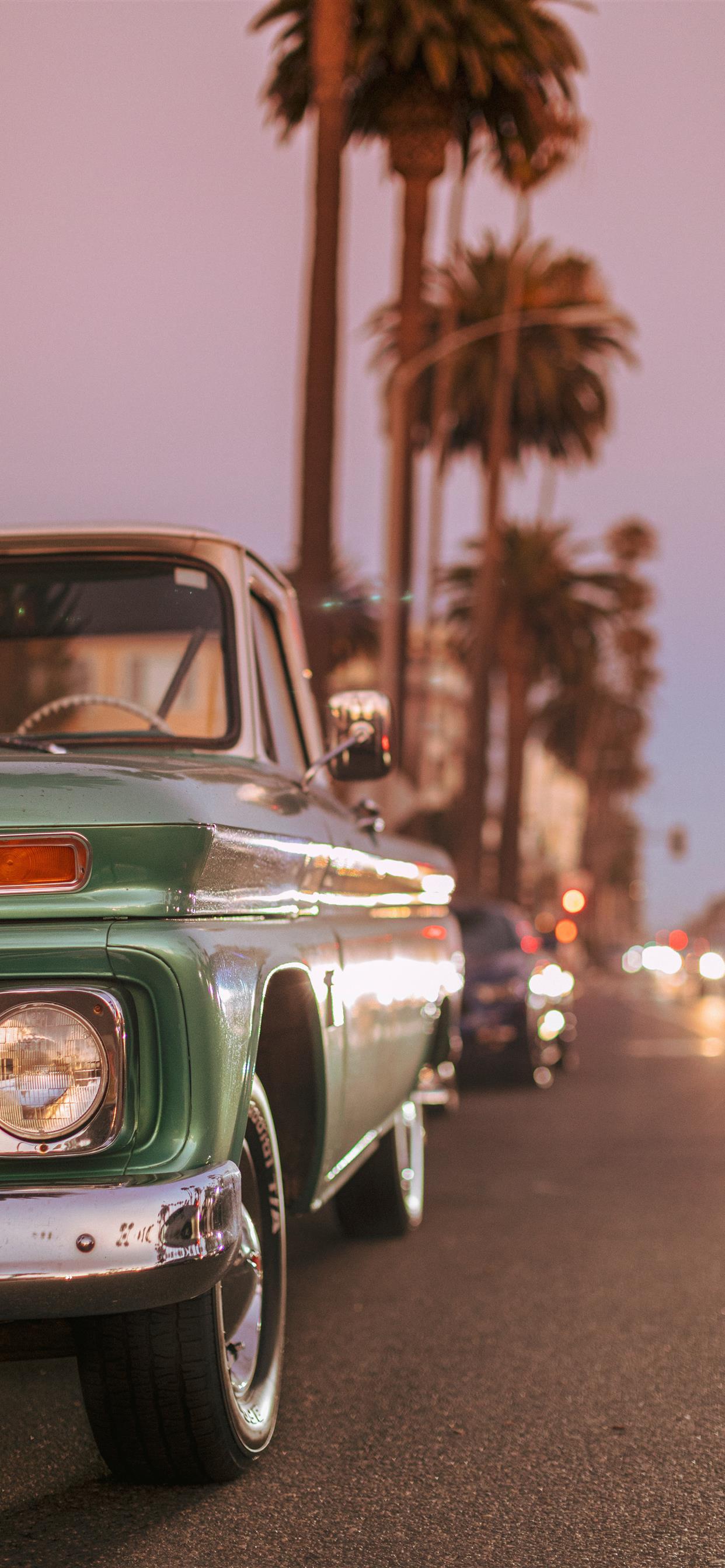 Vintage car parked on Ocean Blvd during sunset iPhone X Wallpaper