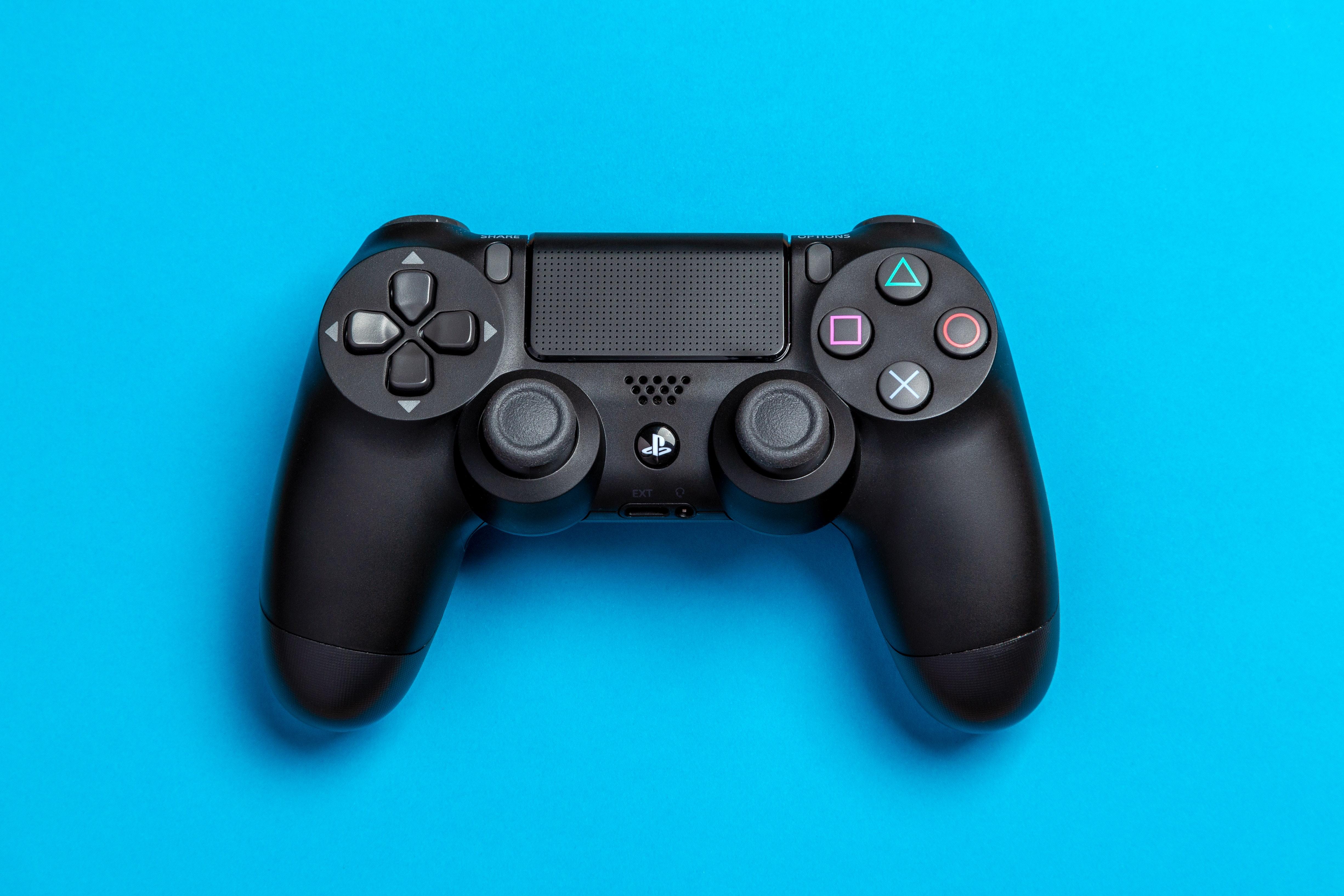 Flat Lay Photo of Black Sony PS4 Game Controller on Blue